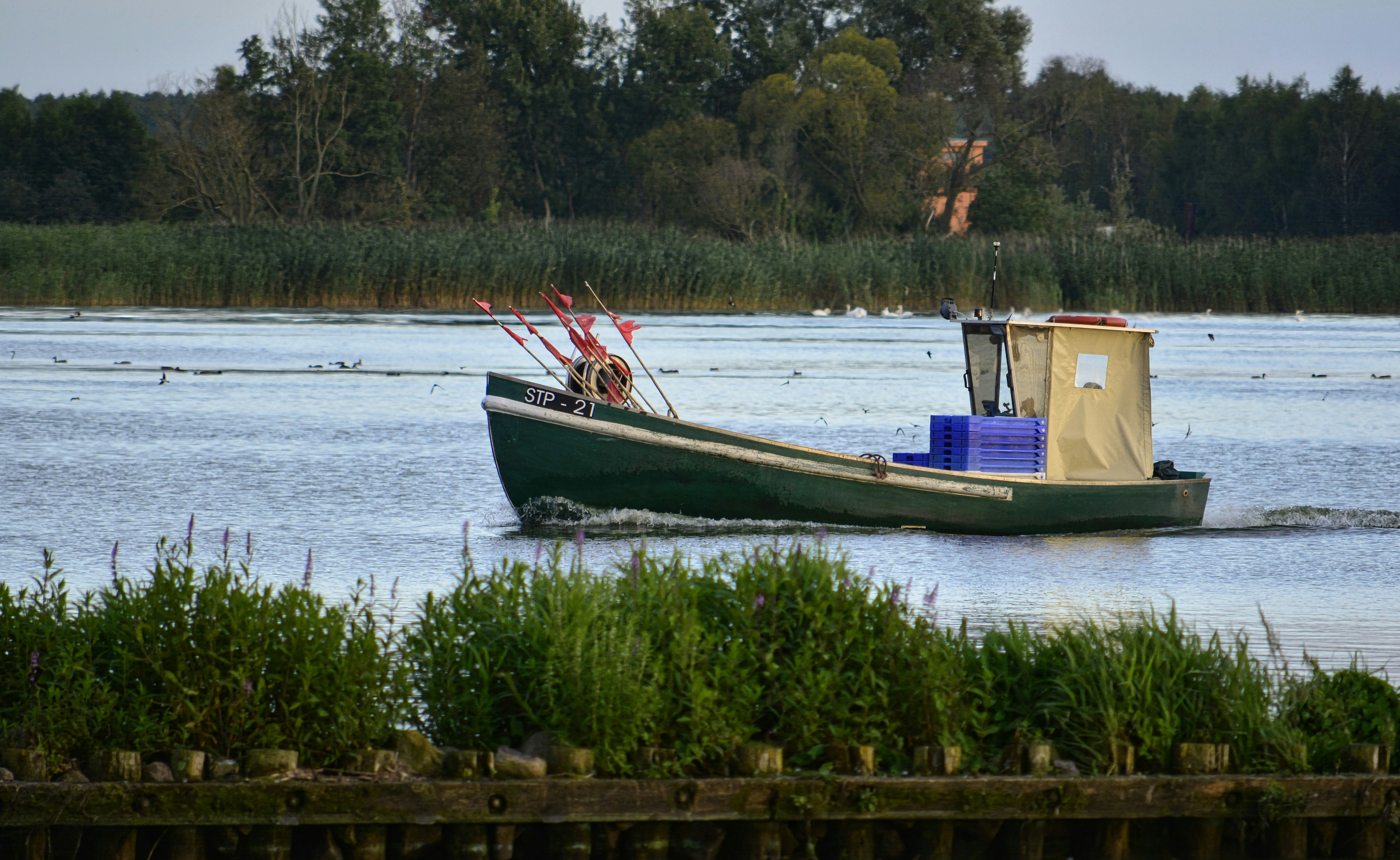 A small fishing boat sails on a calm lake.