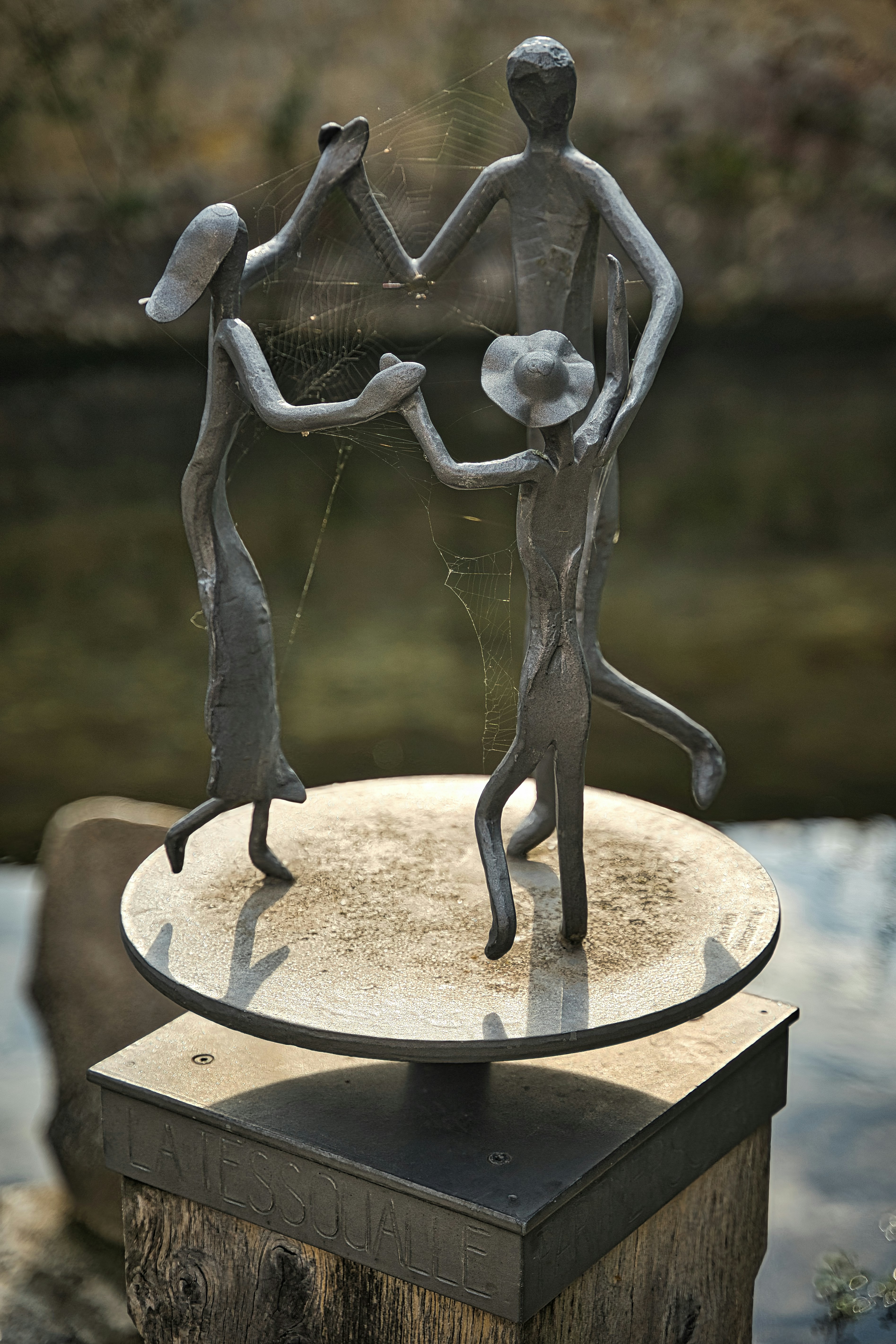 Sculpture of a family dancing on a platform.