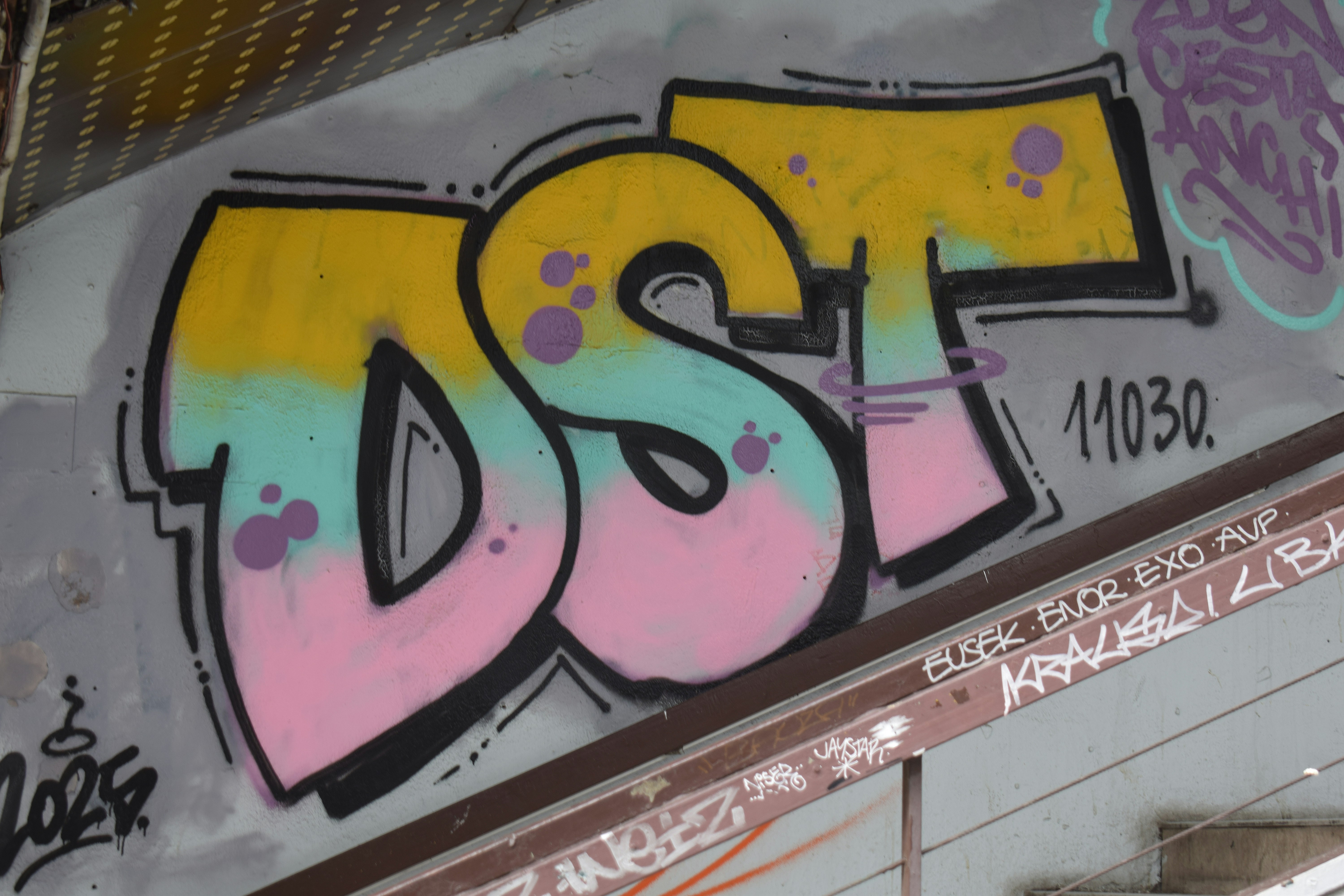 Colorful graffiti art spelling dst on a wall