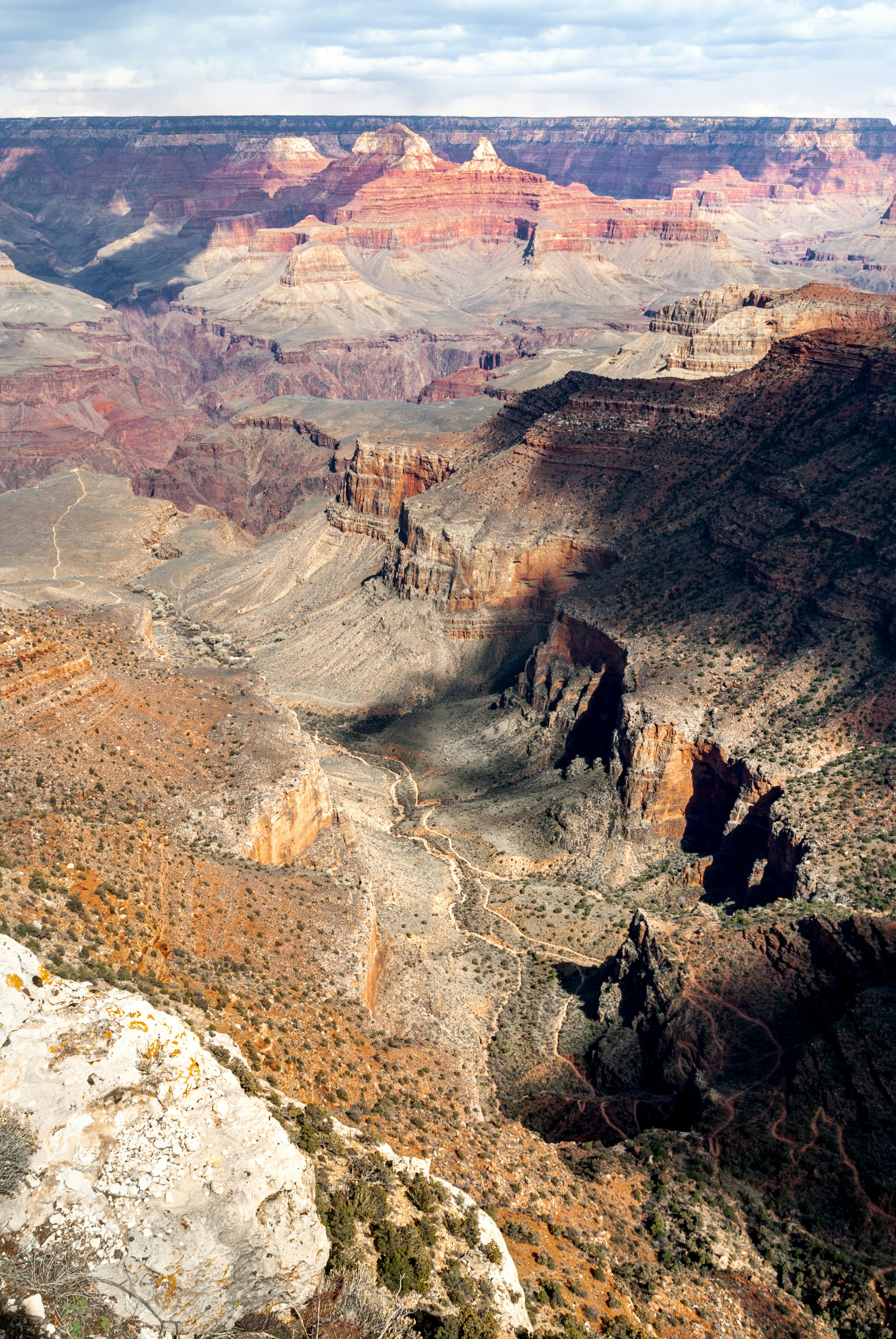 Vast canyon landscape with layered rock formations and shadows.