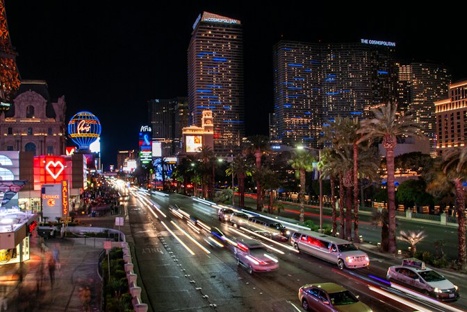Las Vegas cityscape at night with car light trails, showing the busy traffic corridors where robotaxis now operate