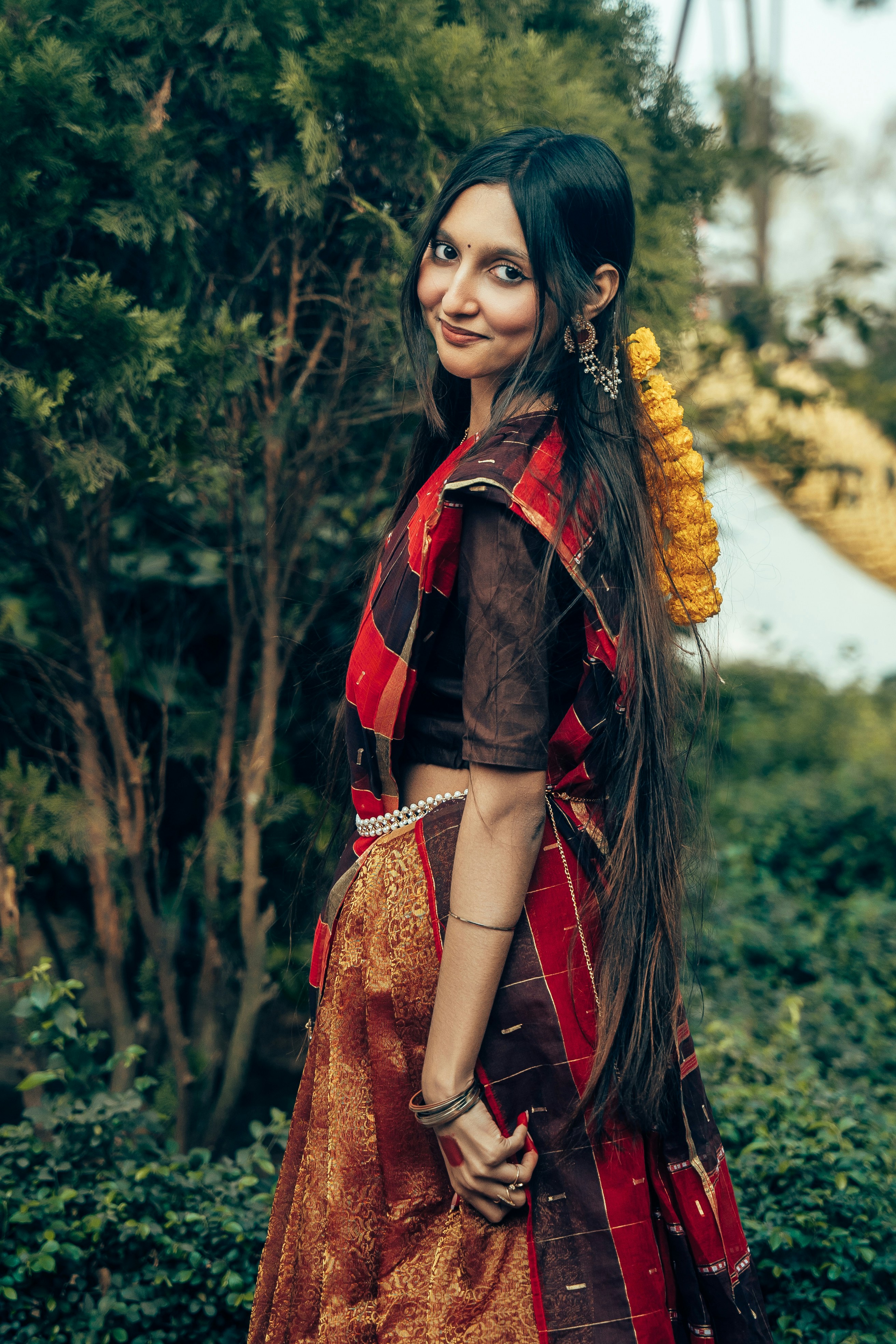 Eine Frau in traditioneller indischer Kleidung lächelt sanft.