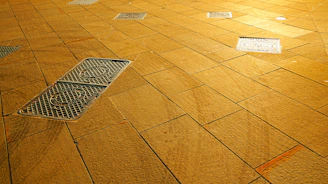 A textured wooden floor with metal grates