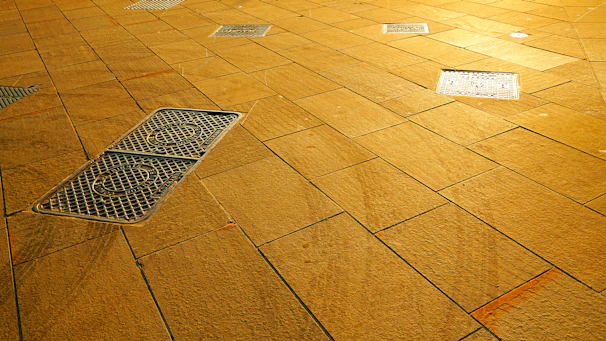 A textured wooden floor with metal grates