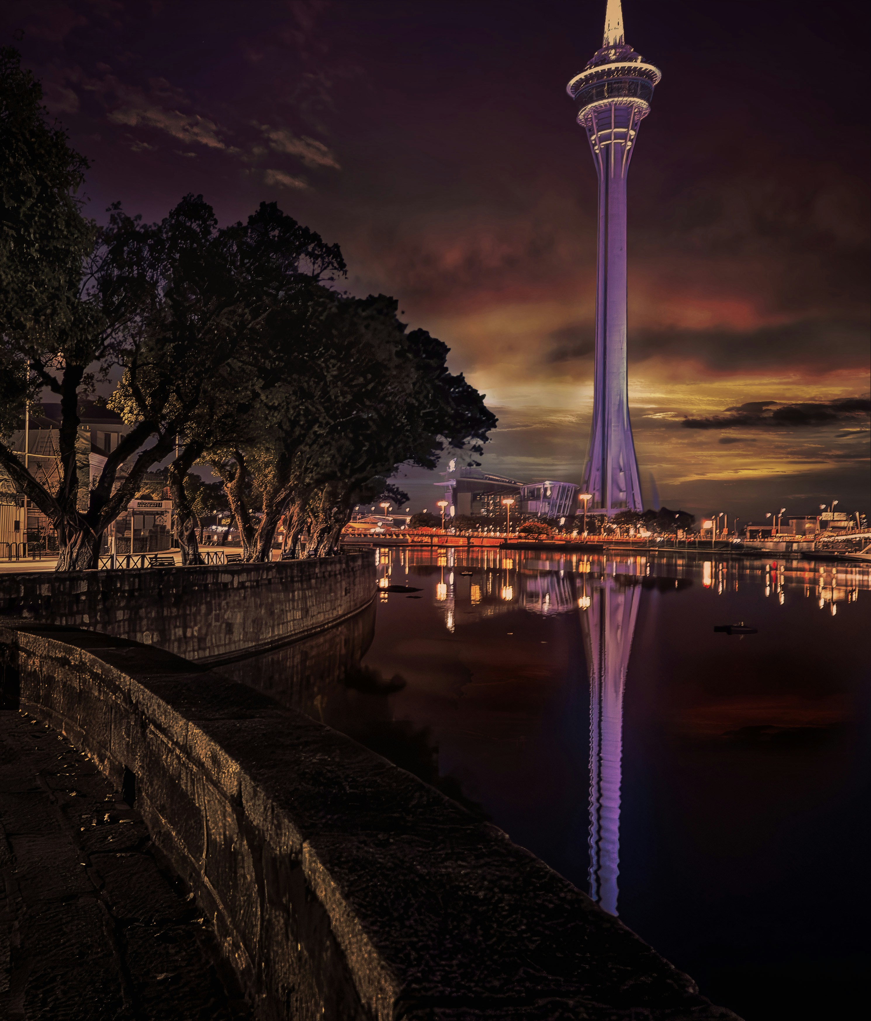 Tall tower reflects in water at twilight