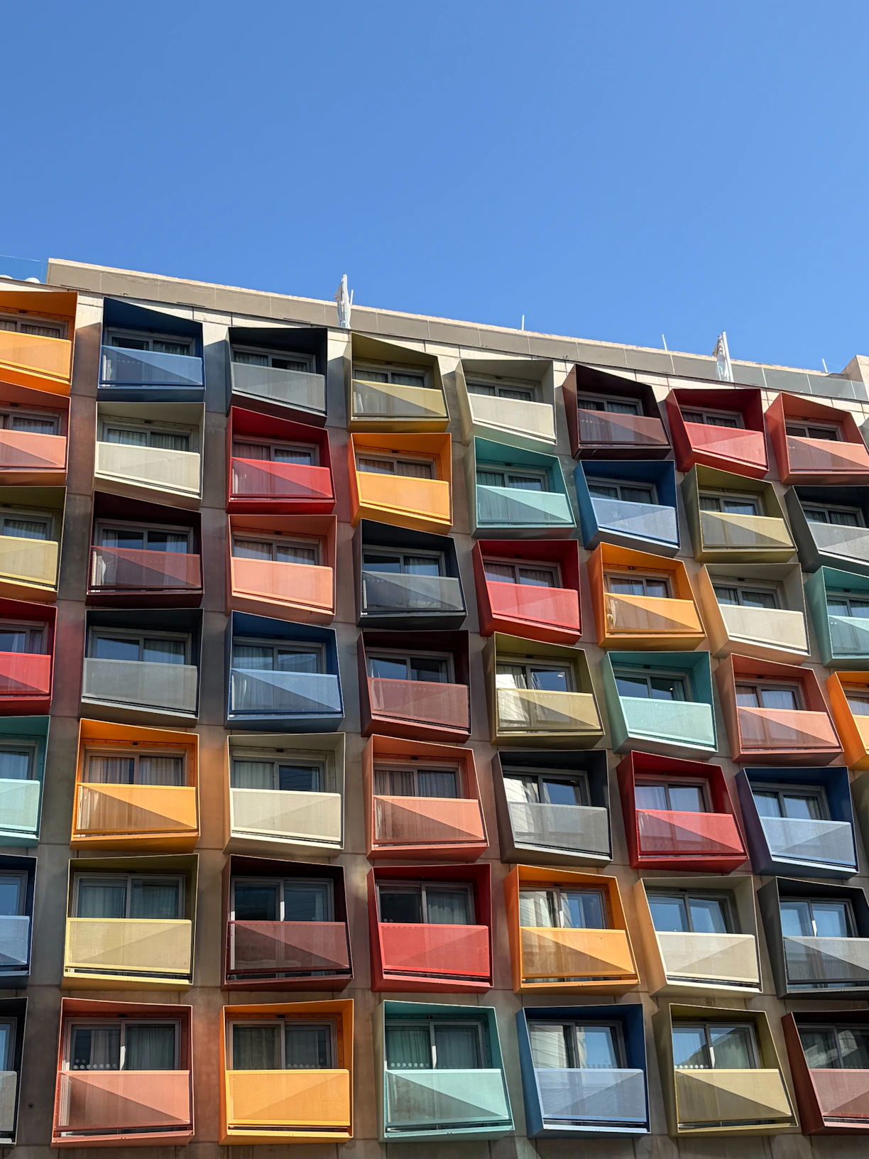 Colorful balconies on a modern building under blue sky