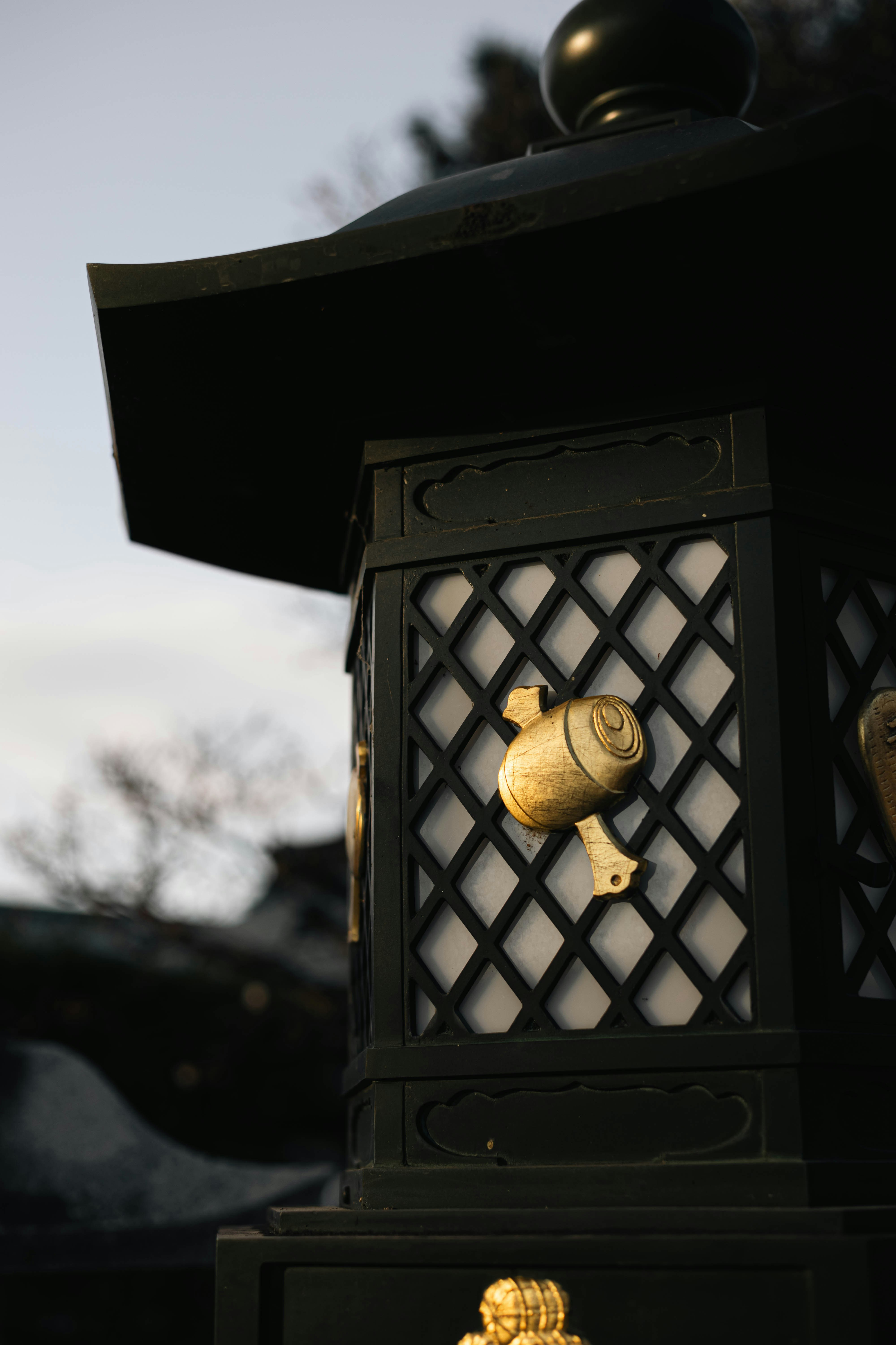 A dark, ornate japanese lantern with gold accents.