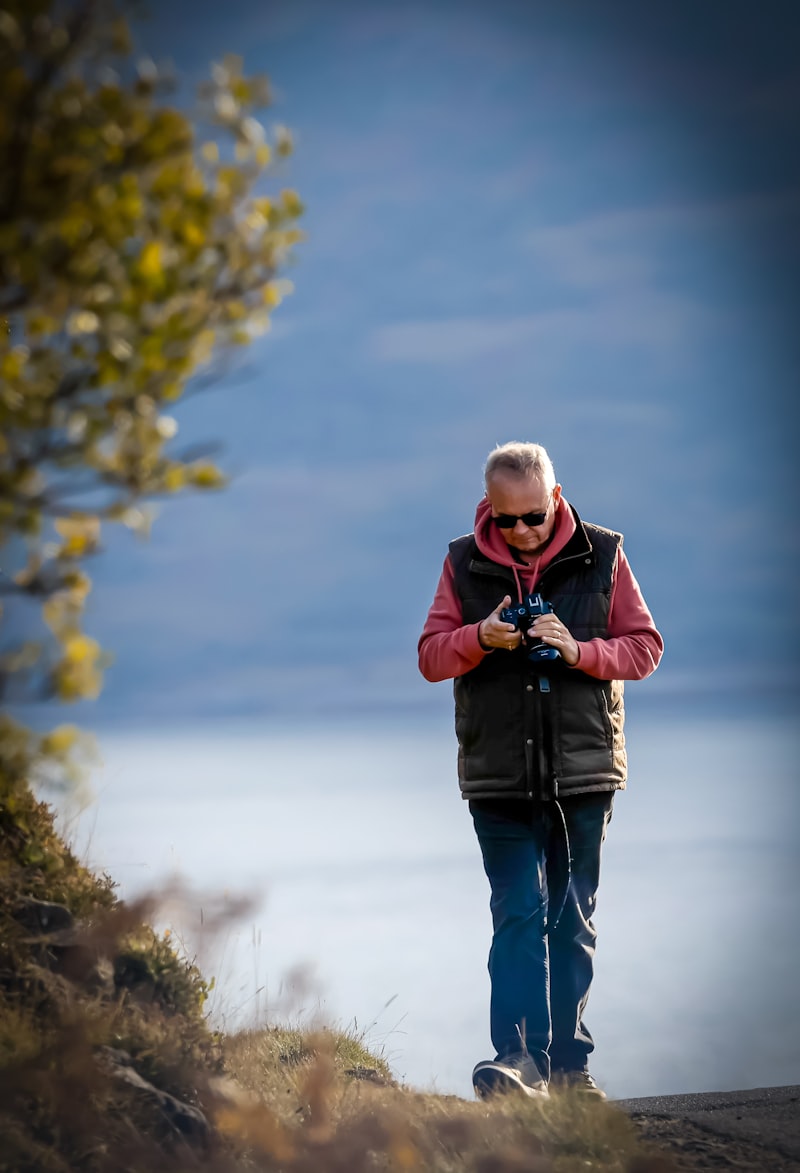 Older adult enjoying nature observation outdoors with bird watching gear