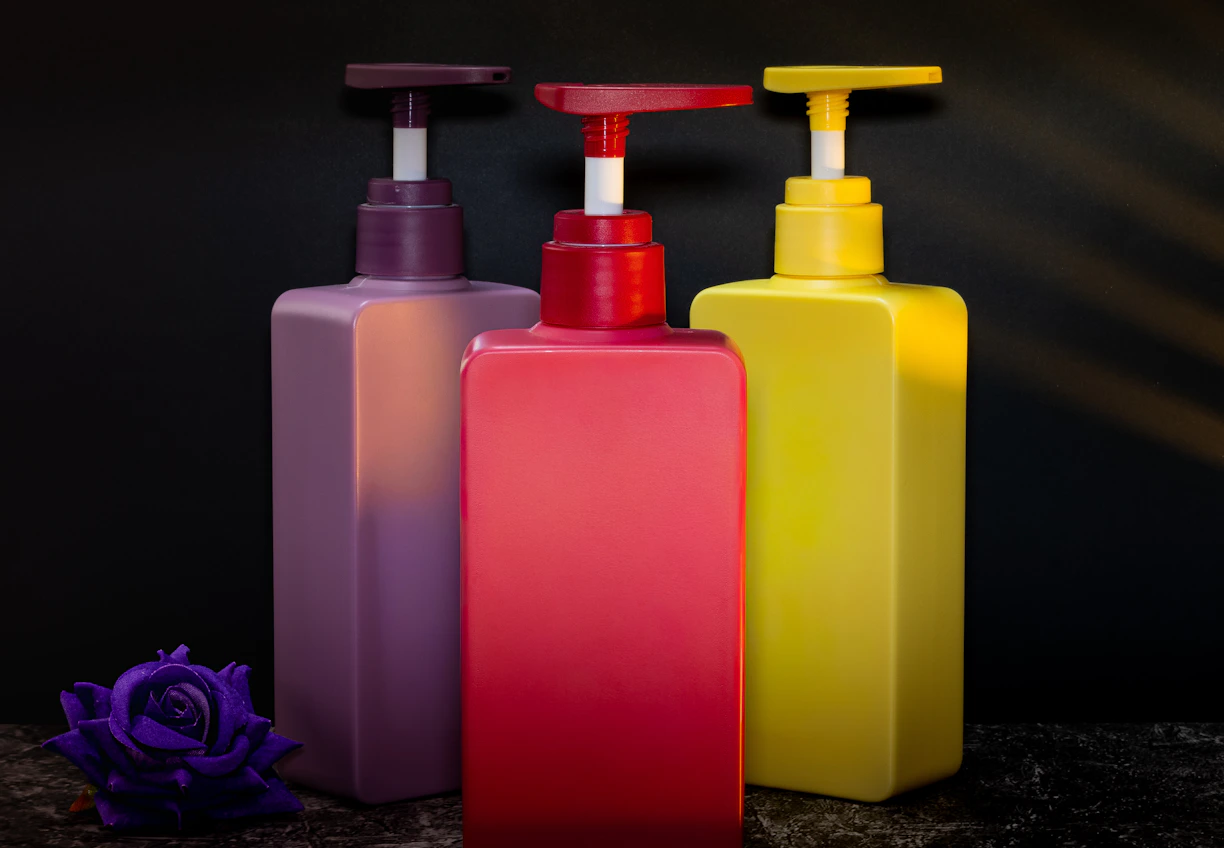 Three colorful pump bottles with a flower