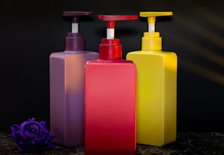 Three colorful pump bottles with a flower