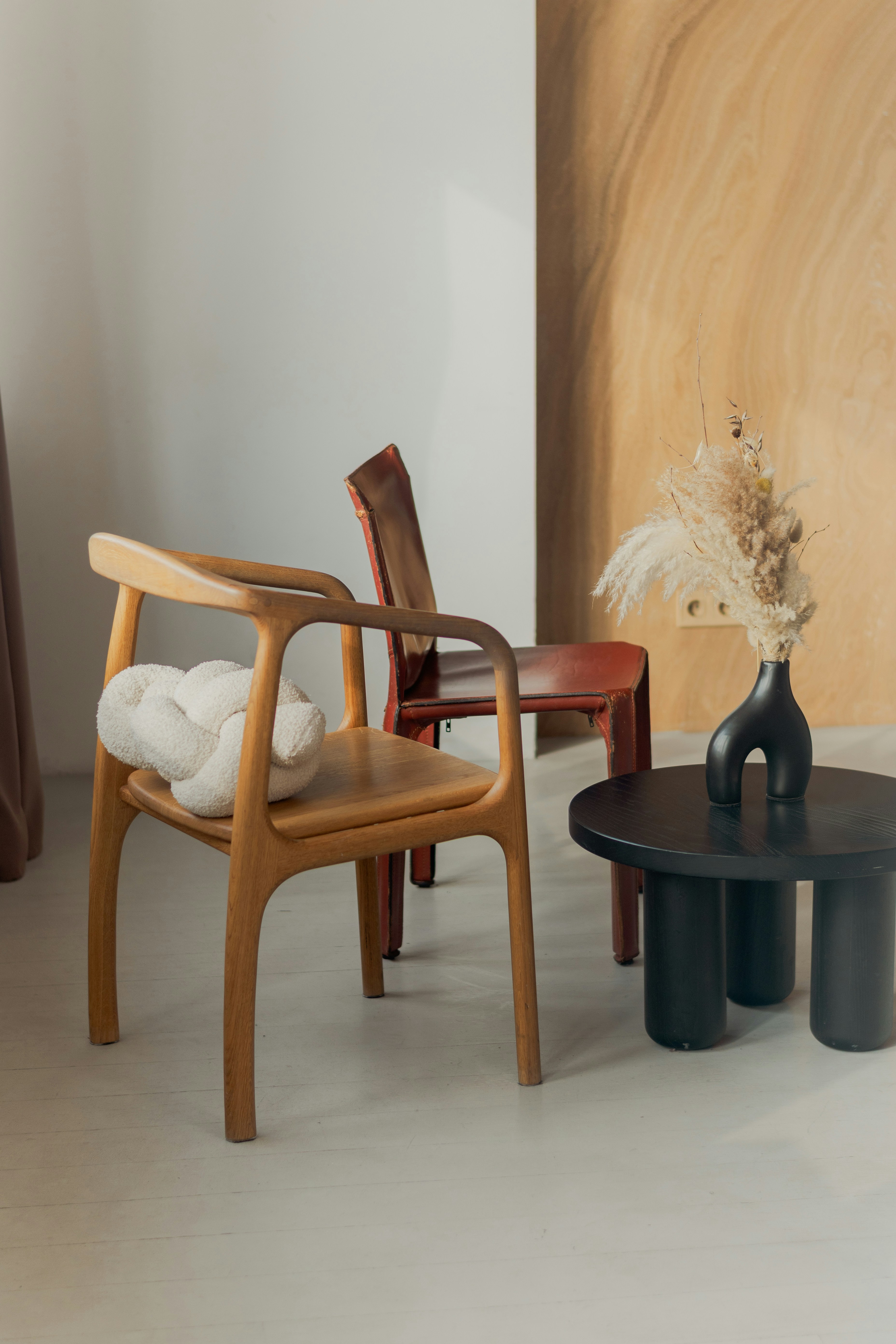 Two chairs and a table with dried flowers.