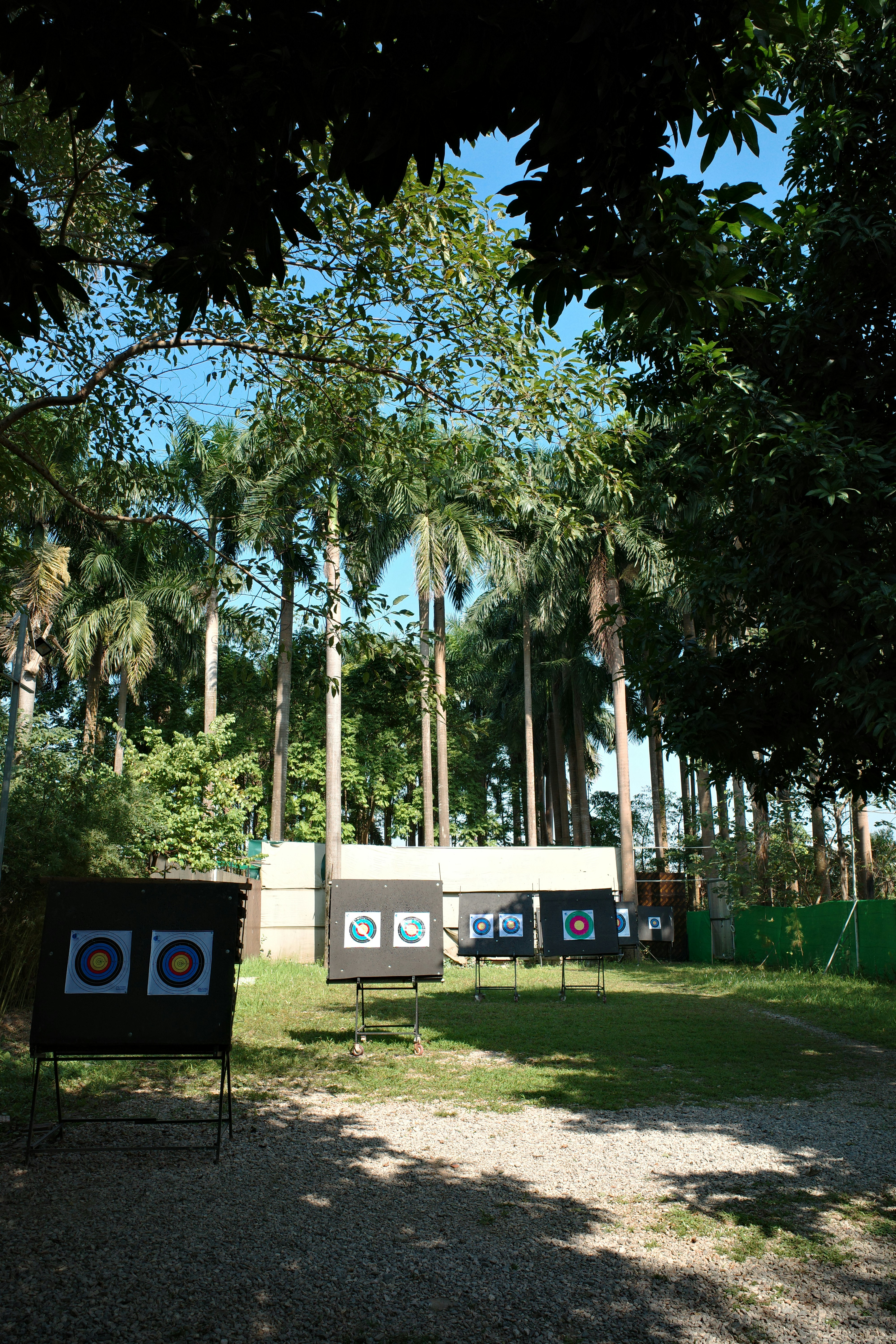 Outdoor archery targets set up on a grassy range with trees in the background