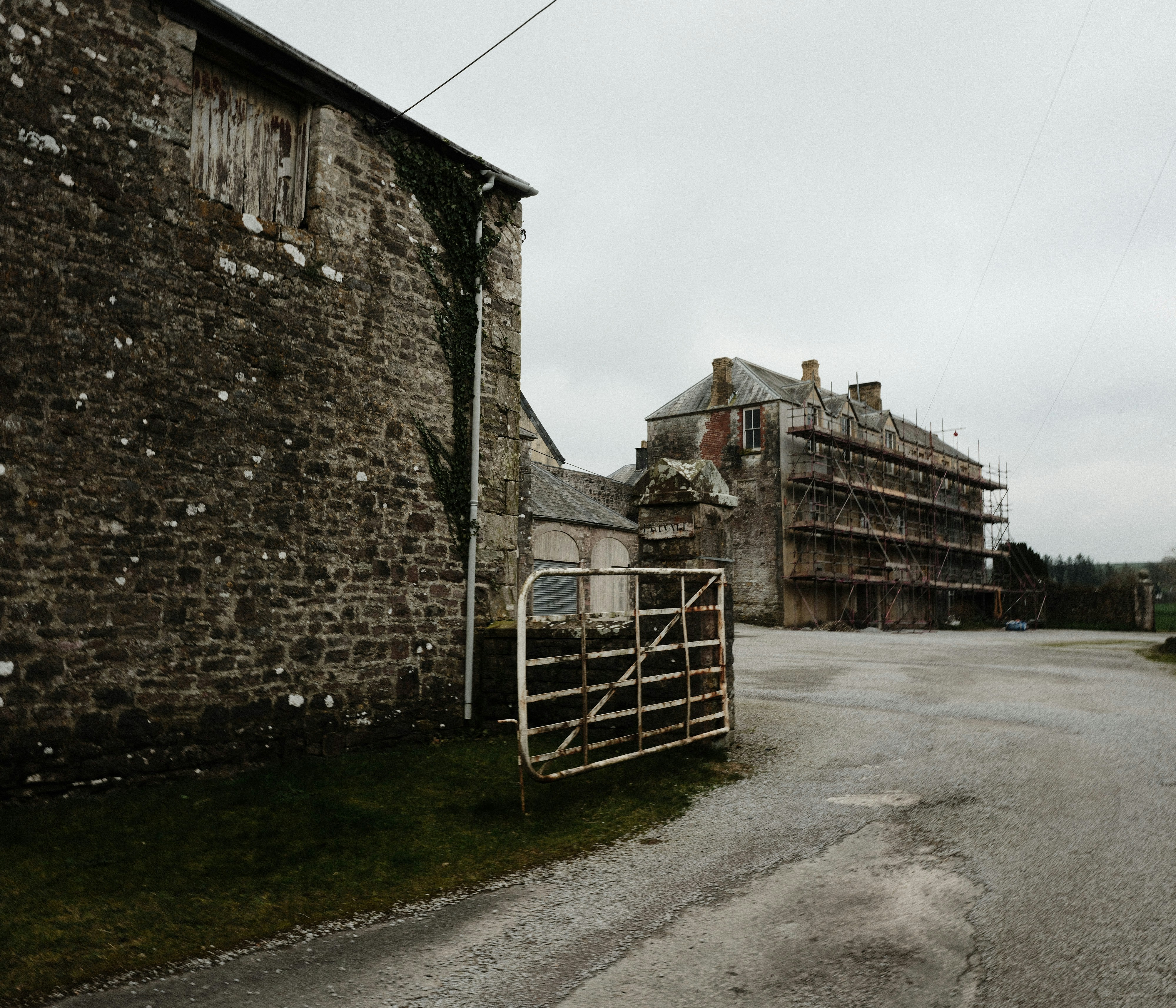Old stone buildings with a metal gate