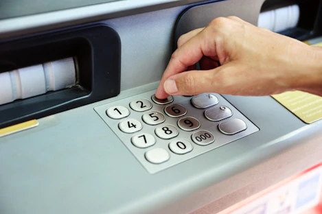 Hand entering pin code on atm keypad