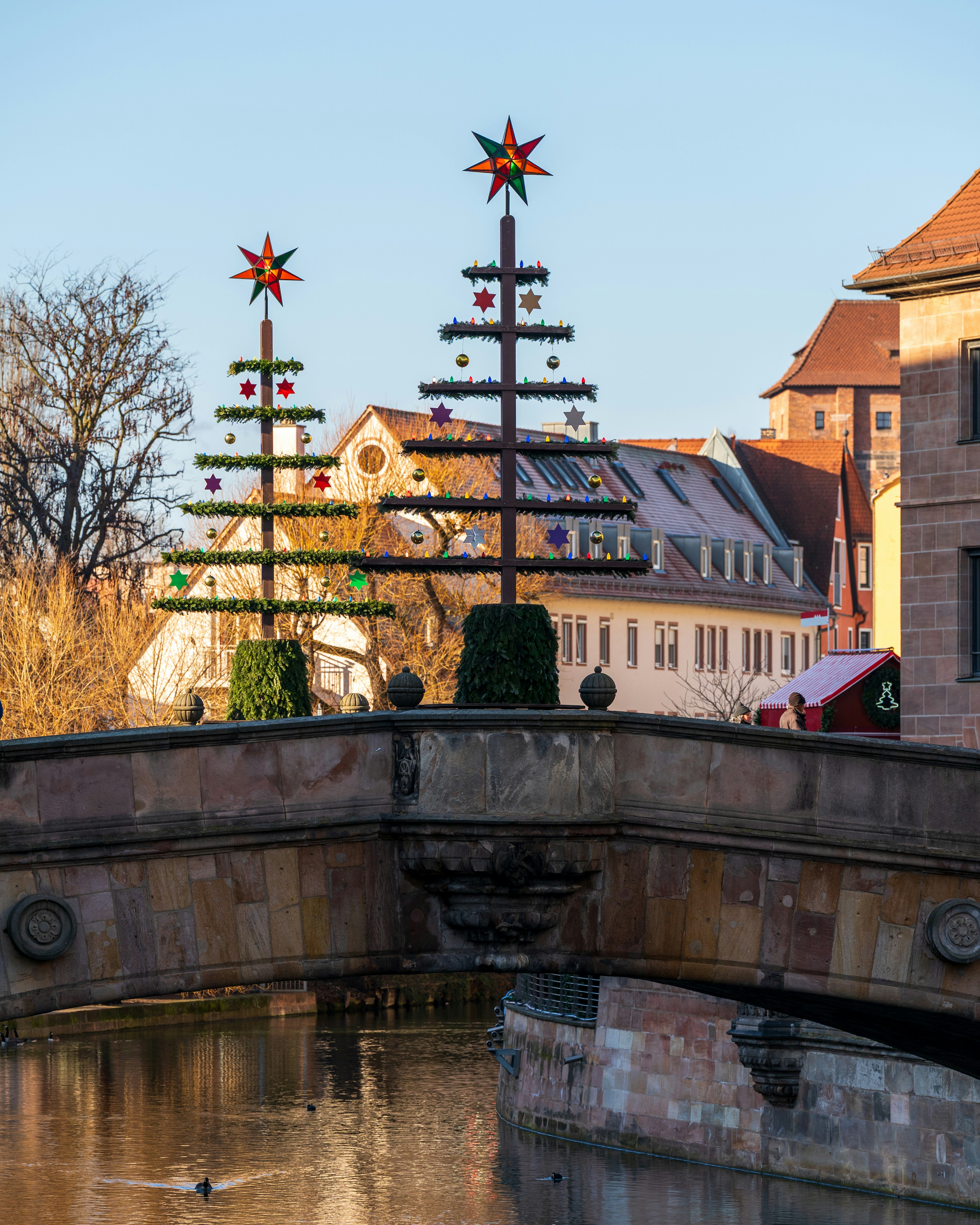 Two decorated trees on a stone bridge