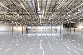 Shiny warehouse floor with overhead lights and ceiling