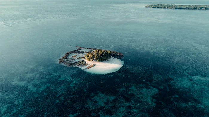 Aerial view of a small secluded reef-fringed island, similar to Cayman Brac and Little Cayman