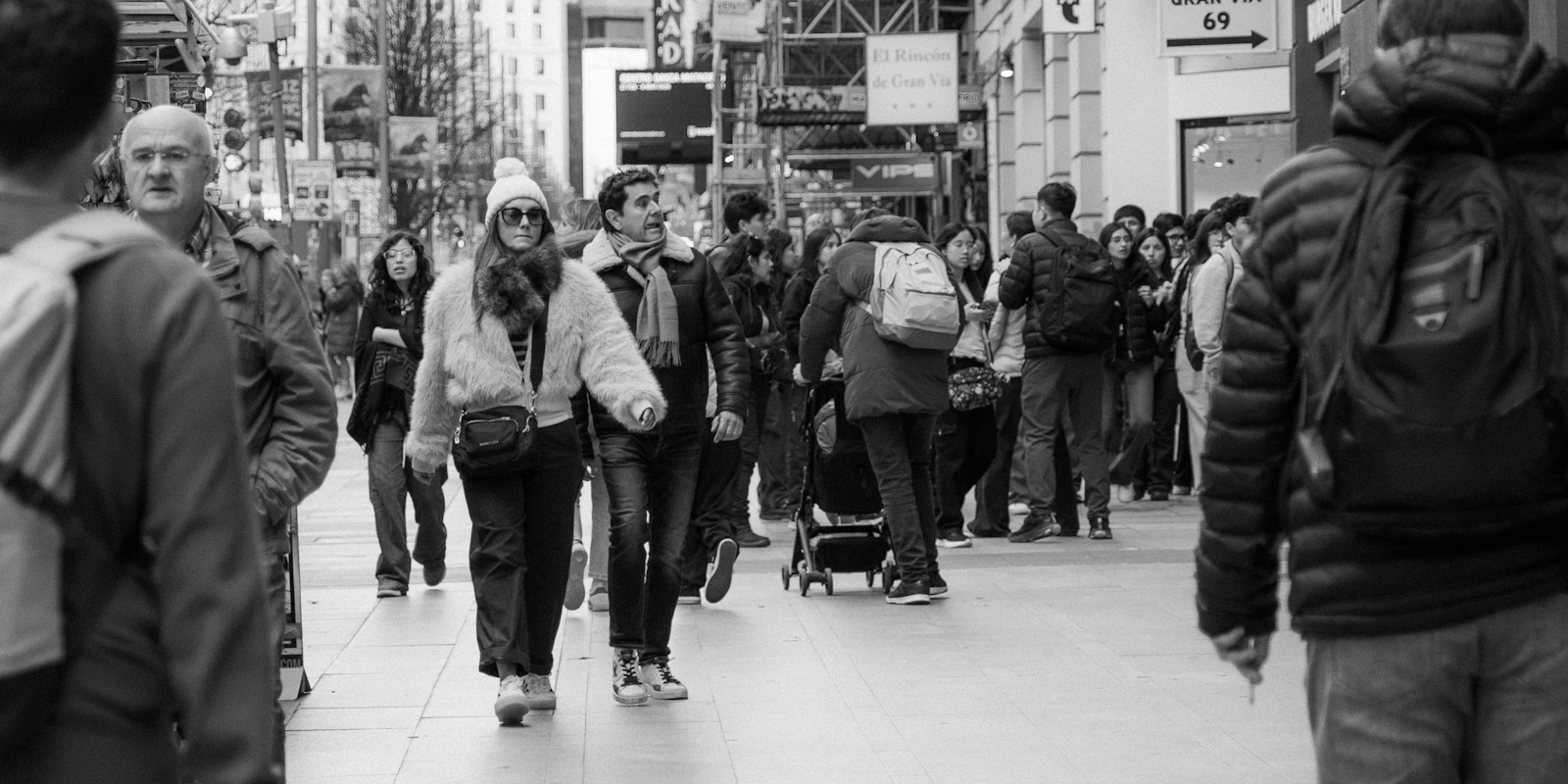 Peatones cruzan una calle céntrica de Madrid por la mañana.