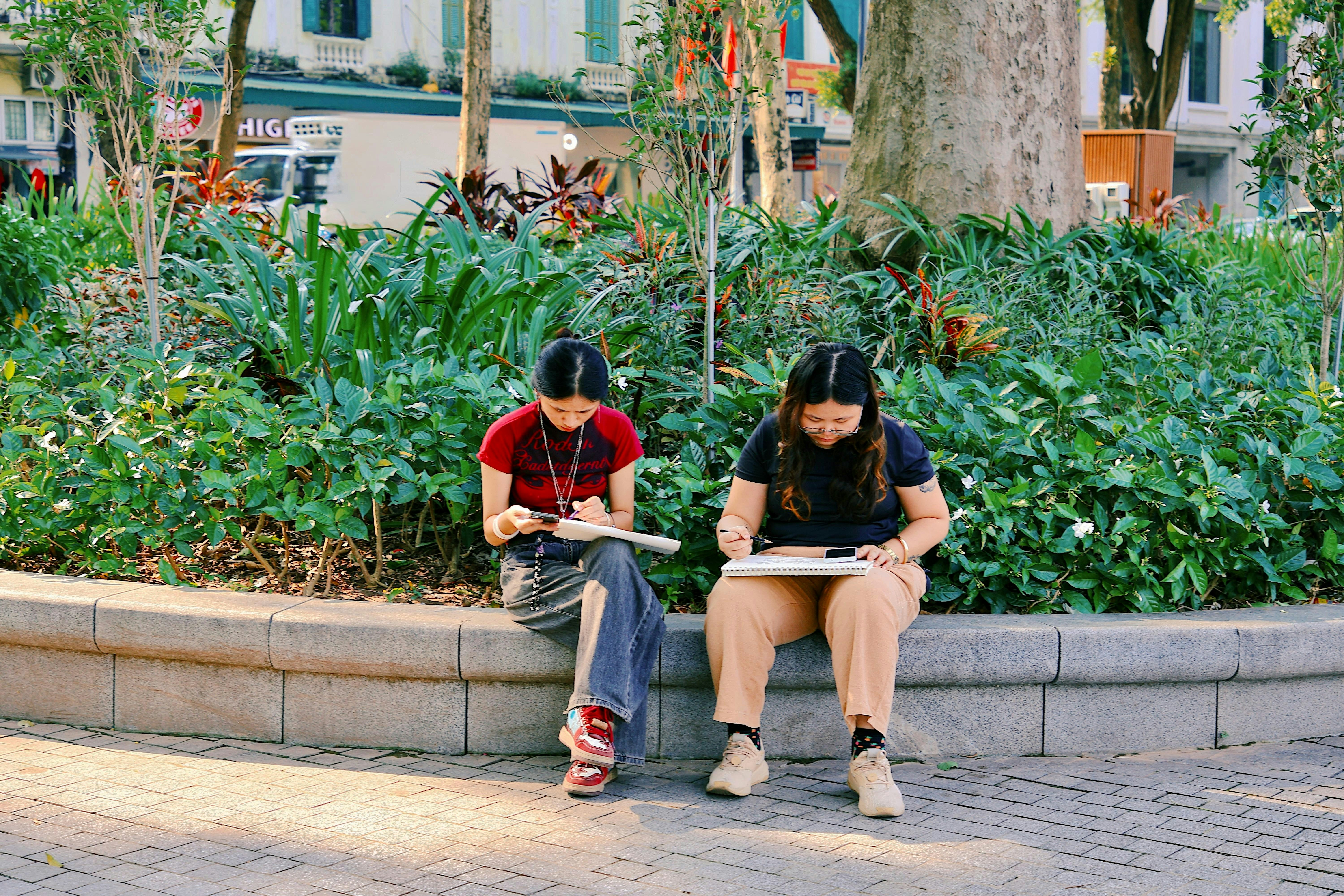 Zwei junge Frauen, die im Park zeichnen