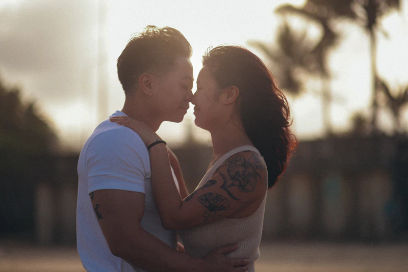 Couple embracing at sunset with palm trees