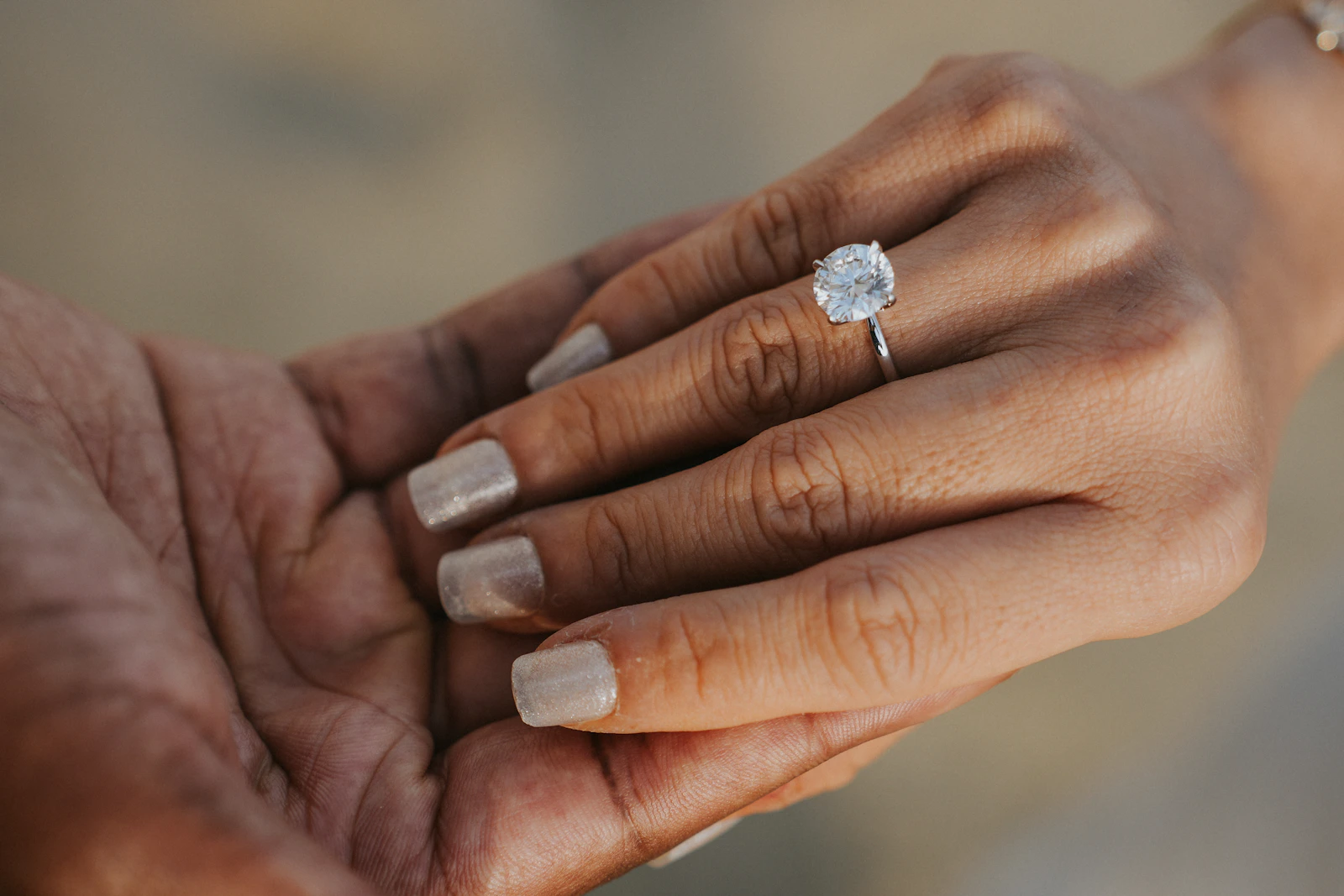A diamond engagement ring worn on a hand, showing how a solitaire looks in everyday life