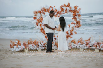 Couple holding hands at a beach wedding ceremony