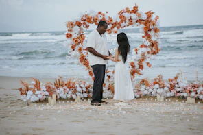 Couple holding hands at a beach wedding ceremony