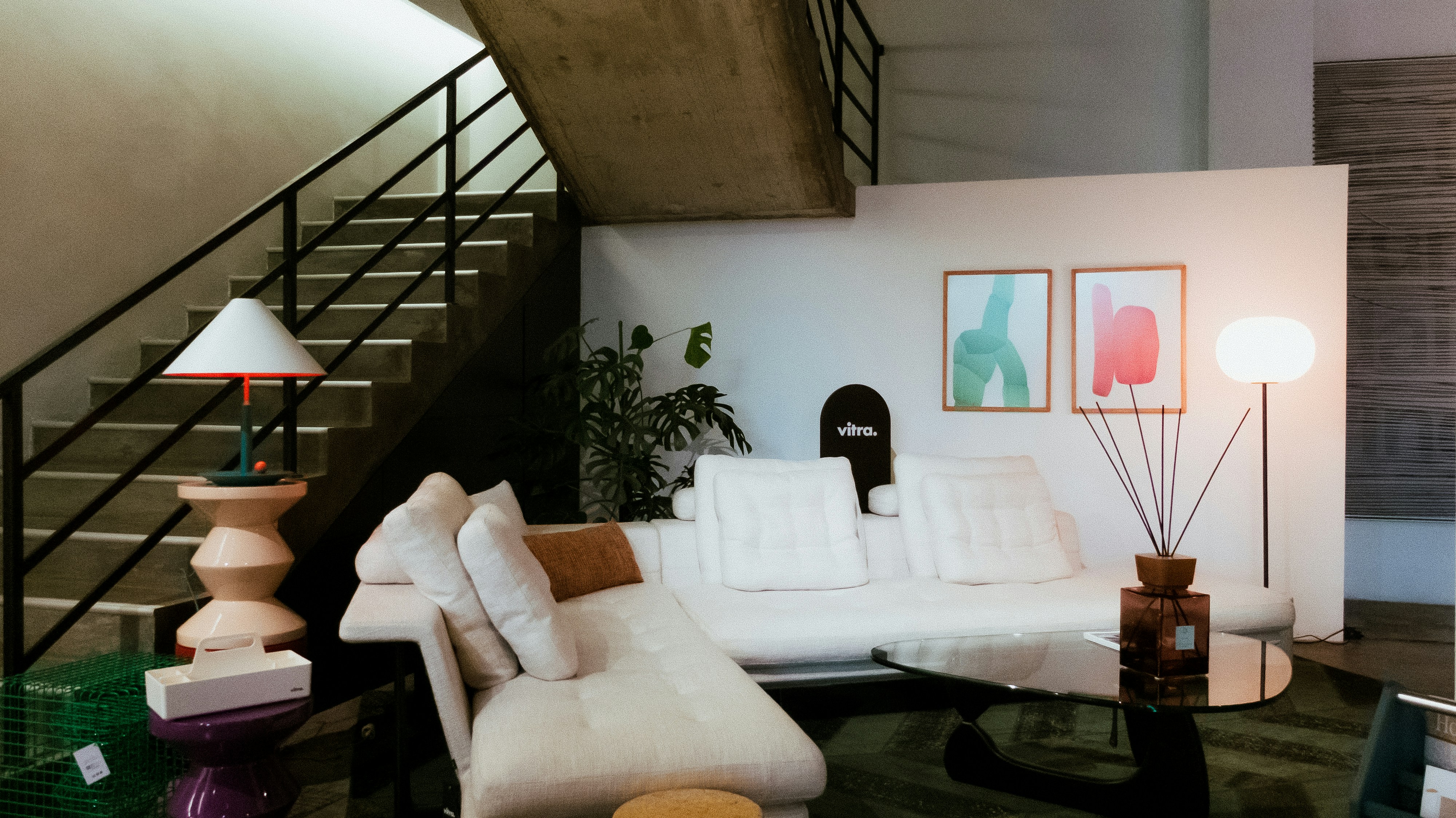 Ruang tamu modern dengan sofa putih dan tangga.