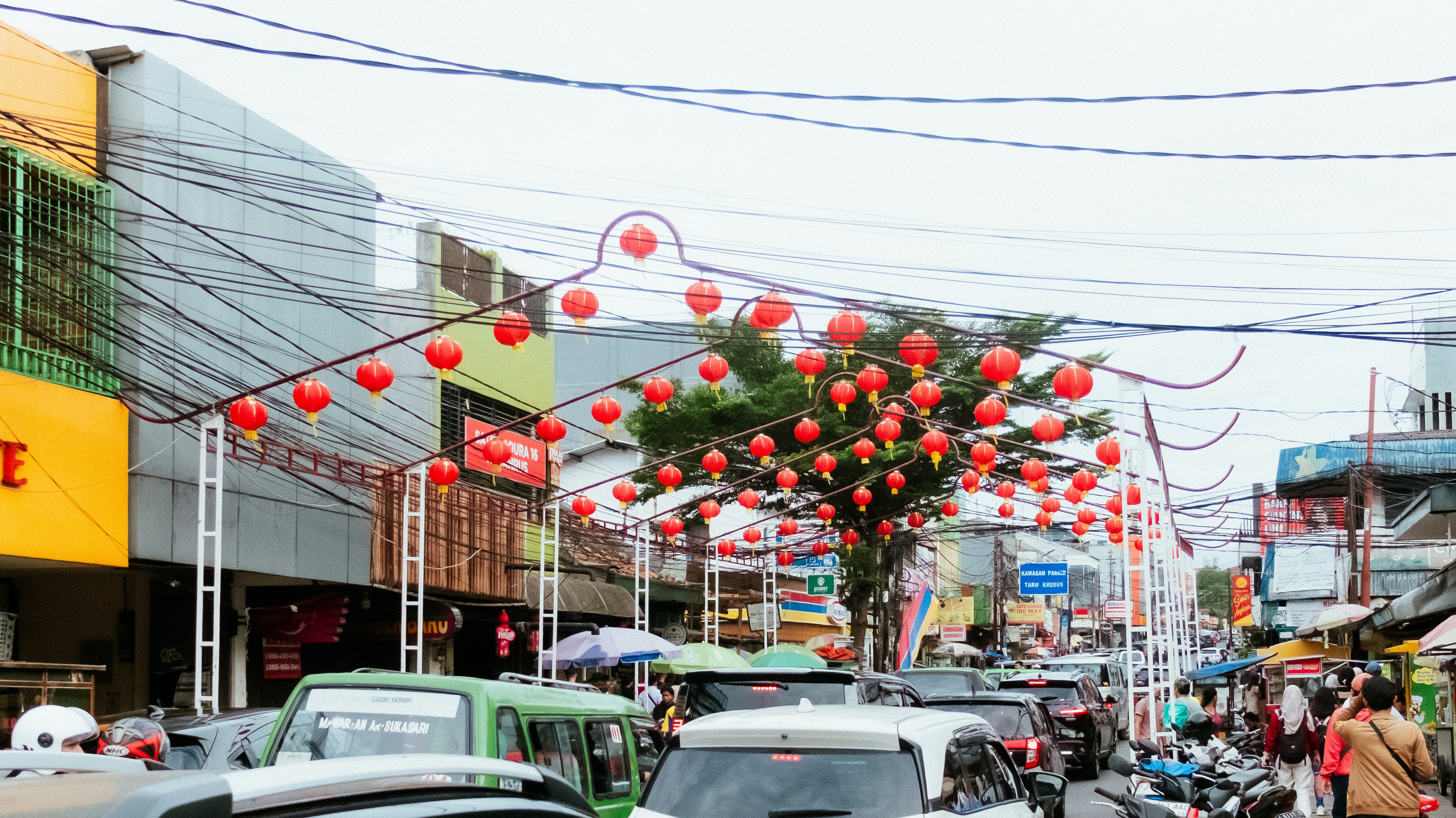Jalan dihiasi dengan lentera merah dan lengkungan