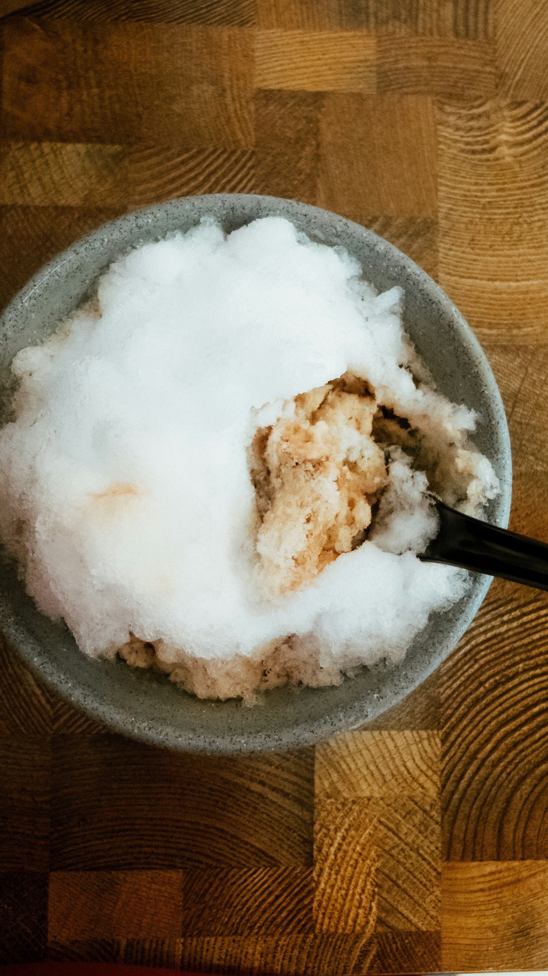 Makanan penutup es serut dalam mangkuk dengan sendok