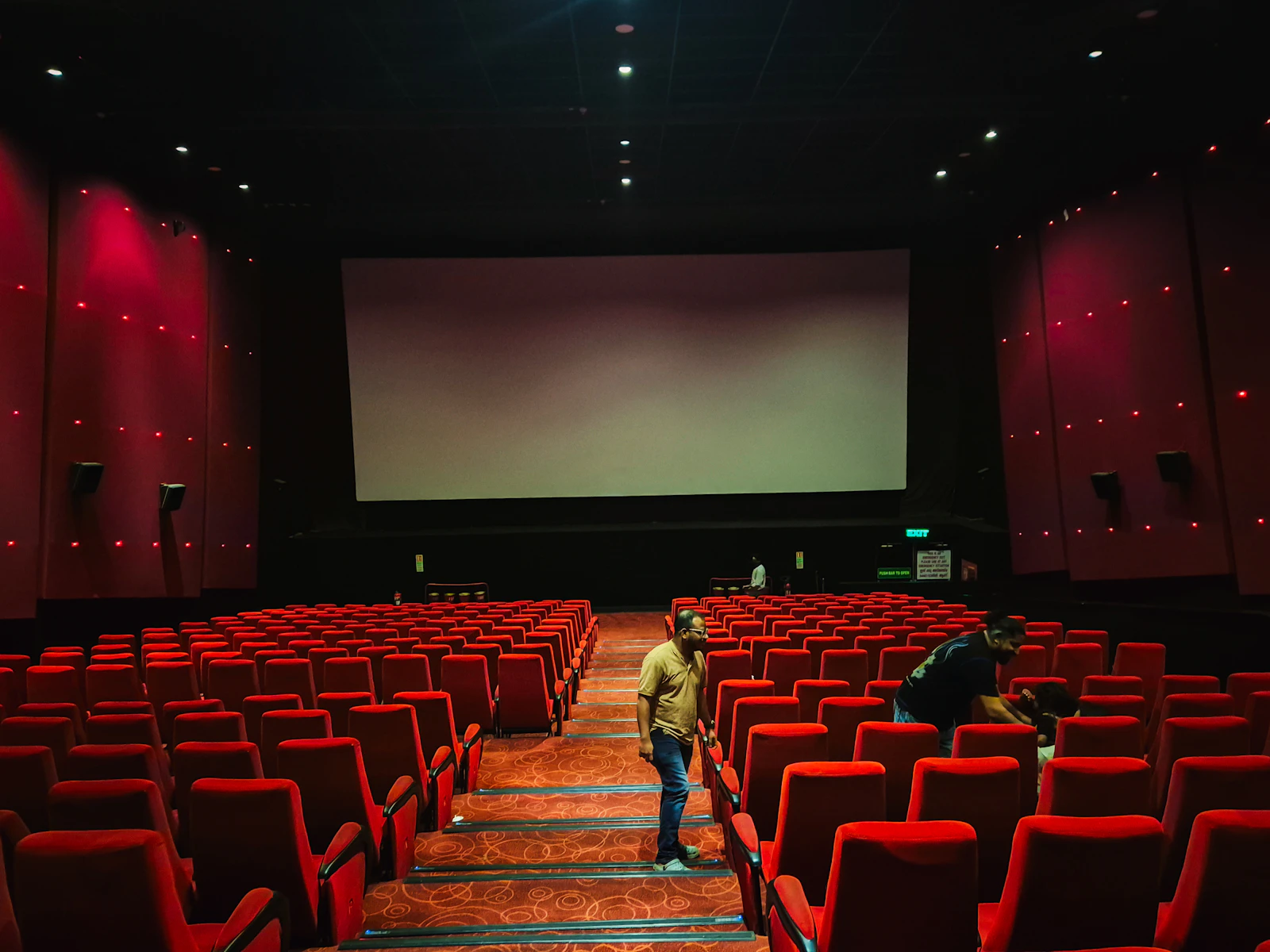 Cinema hall with red seats and a large glowing screen