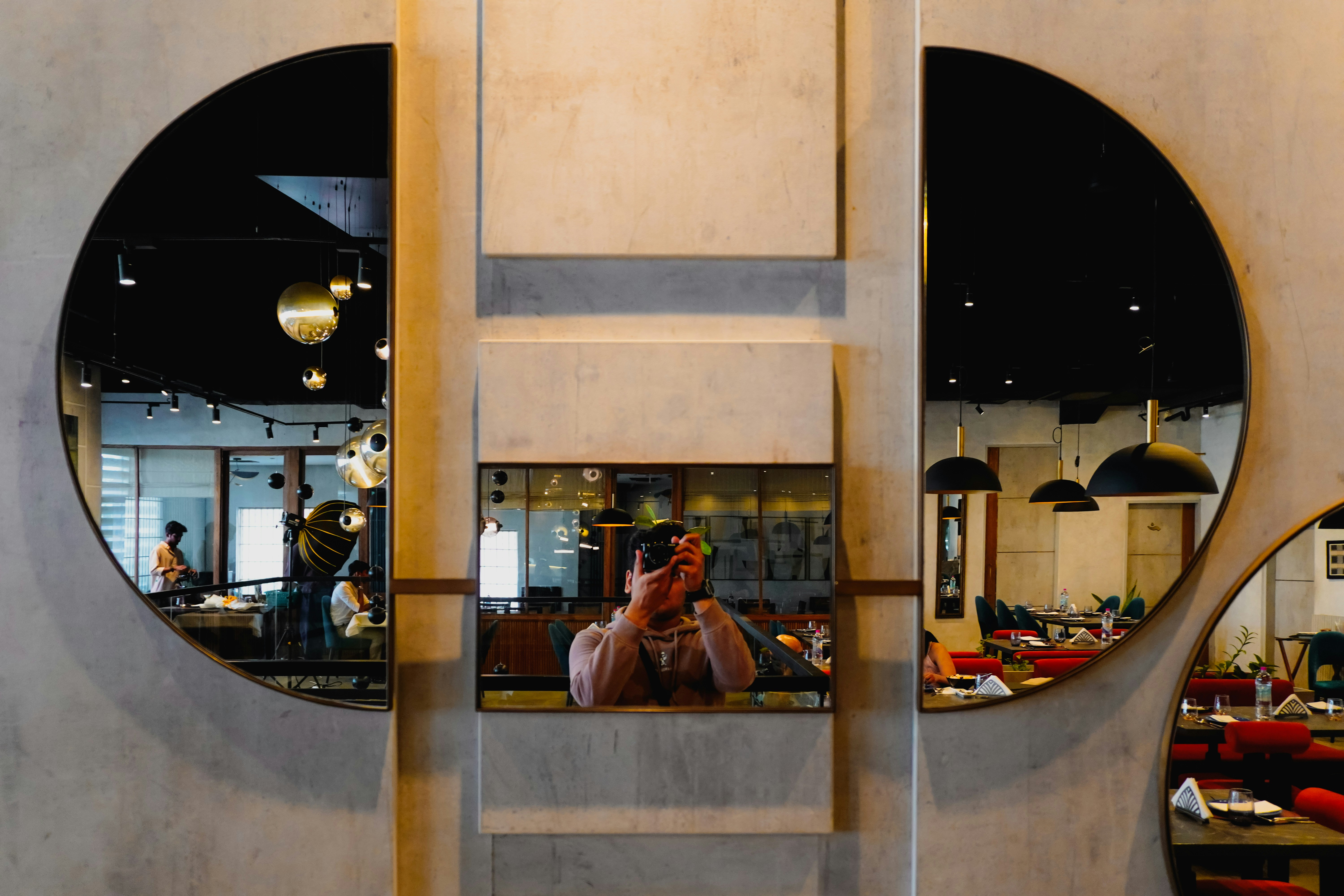 거울이 있는 현대식 카페에서 셀카를 찍는 사람