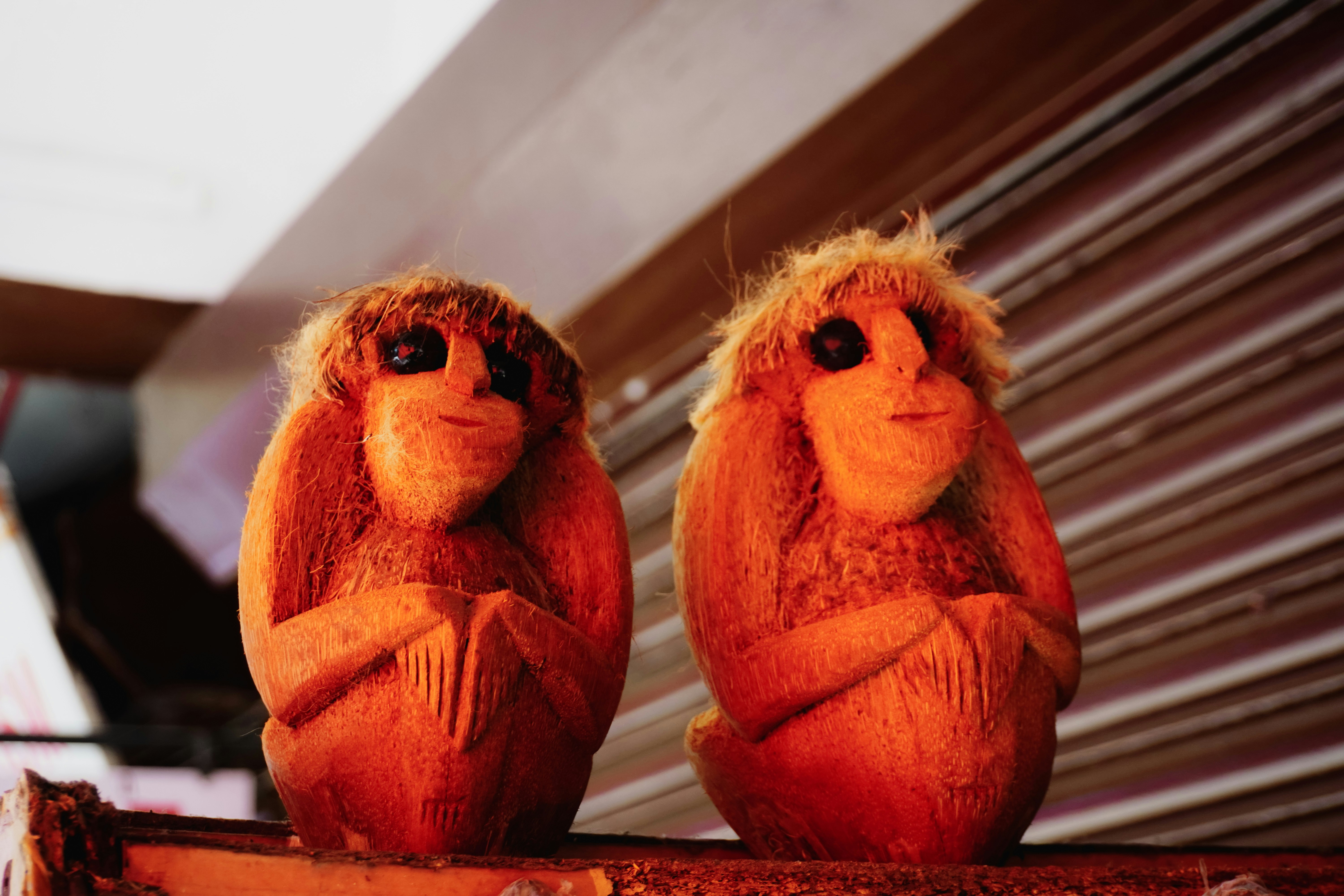 Two carved wooden monkeys with shaggy hair.