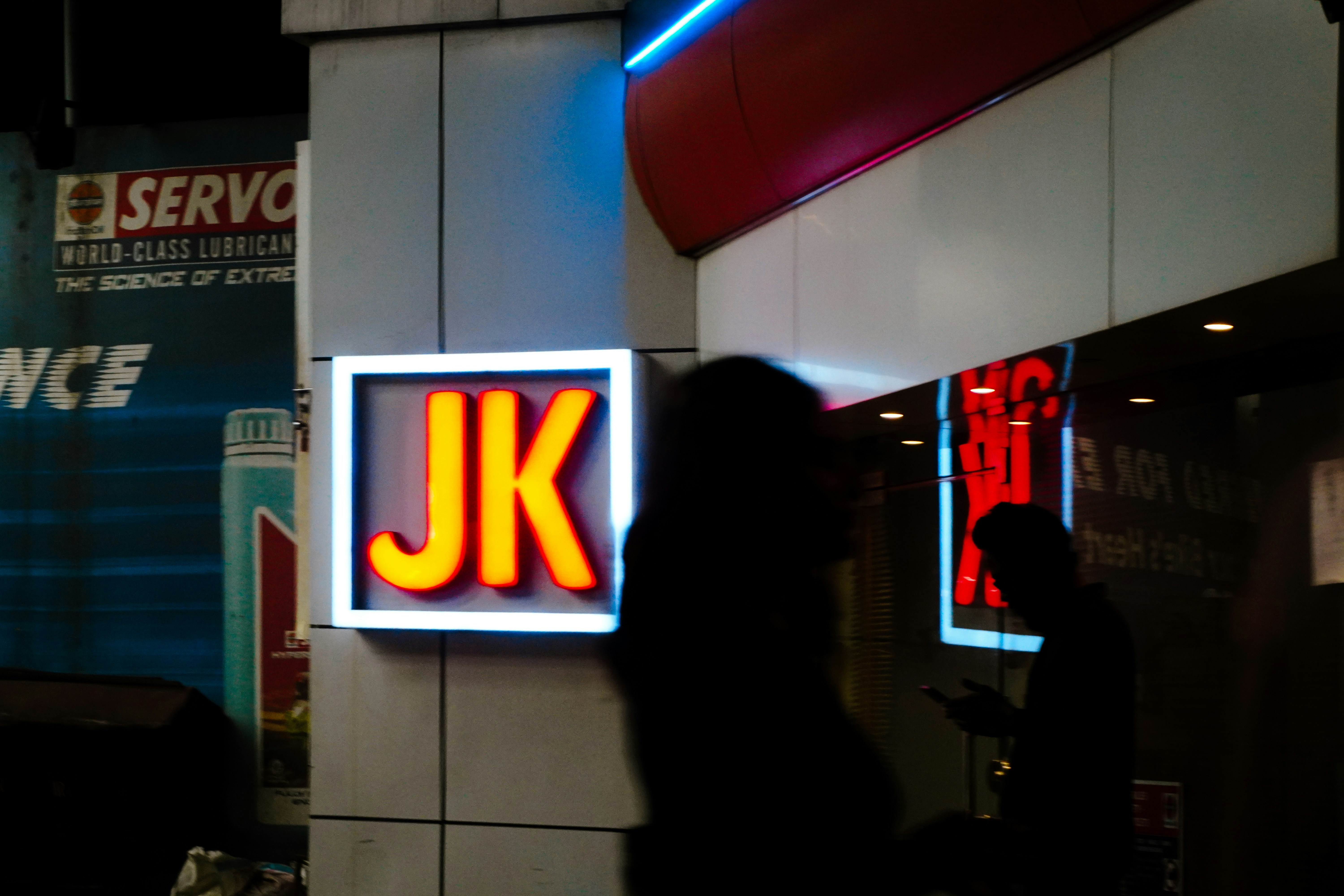 Glowing jk sign outside a building at night