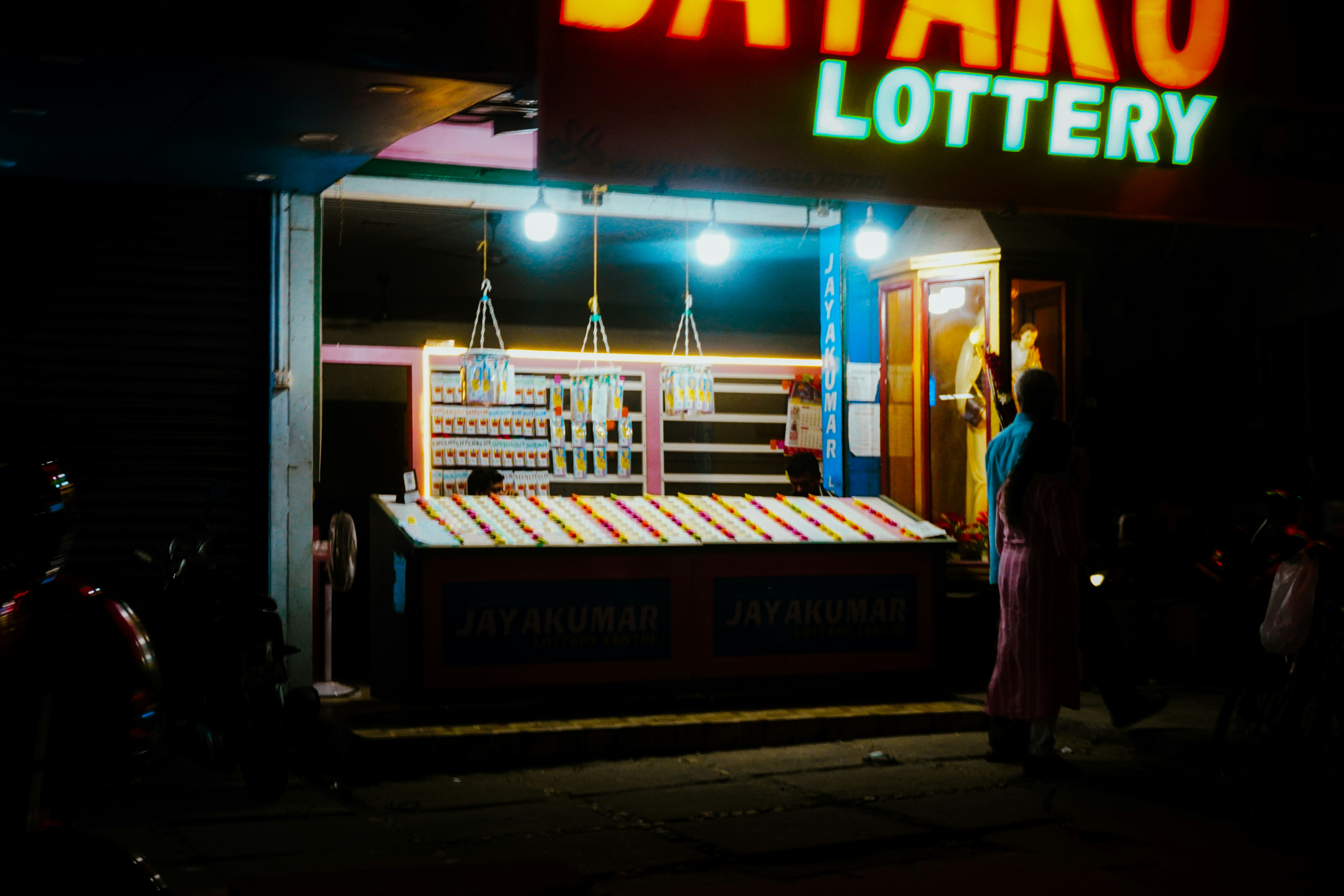 A lottery stall at night with bright lights
