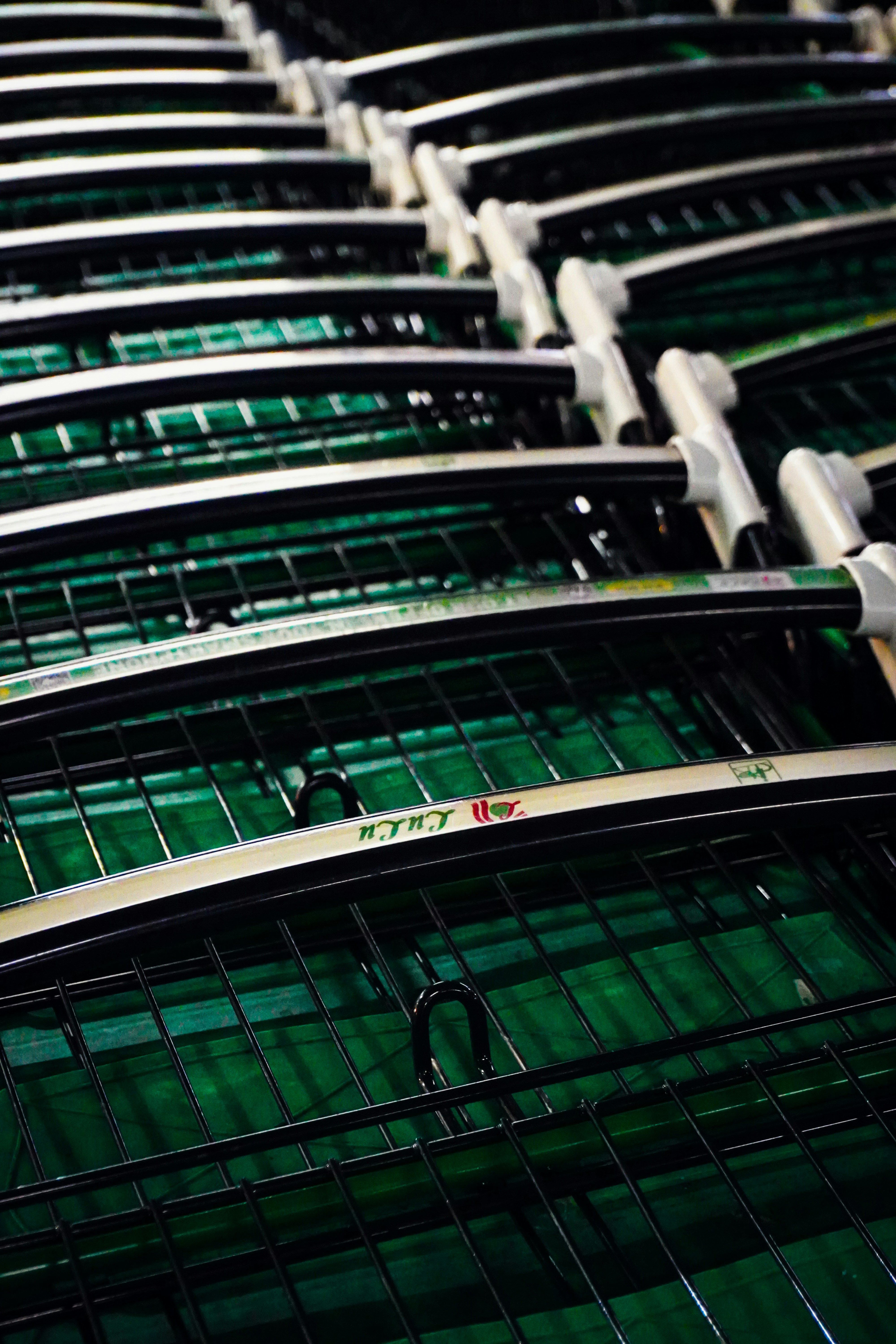 Fileiras de raquetes de tênis em uma superfície verde.