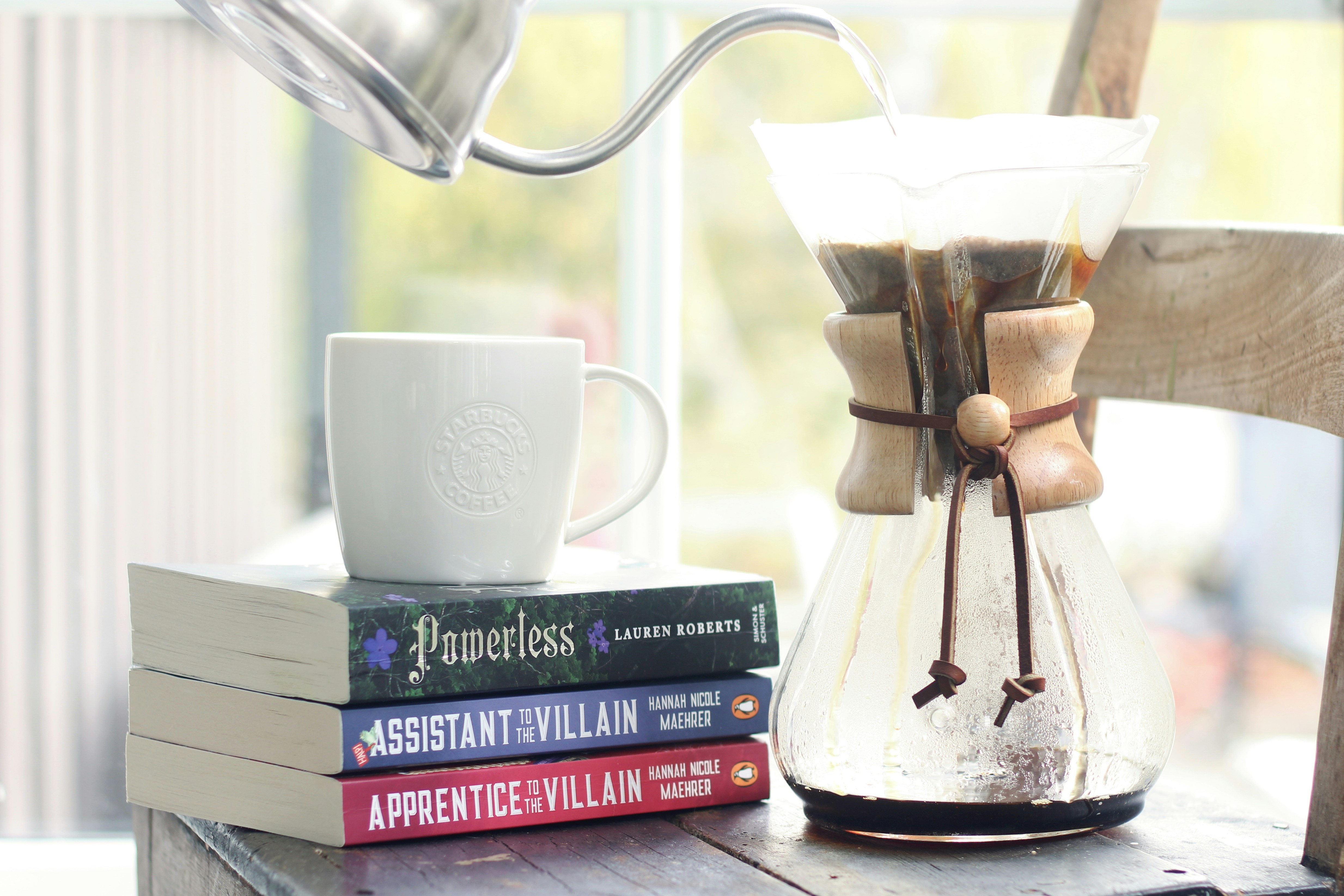Versant de l’eau chaude dans la cafetière à côté des livres.
