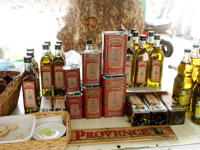 Bottles and cans of olive oil displayed at a market.