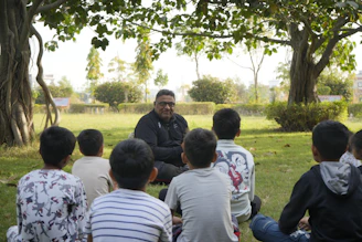 Man tells story to children sitting in a park