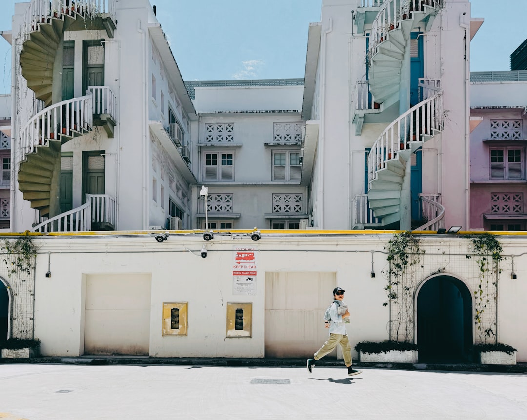 Man running past colorful buildings with spiral staircases