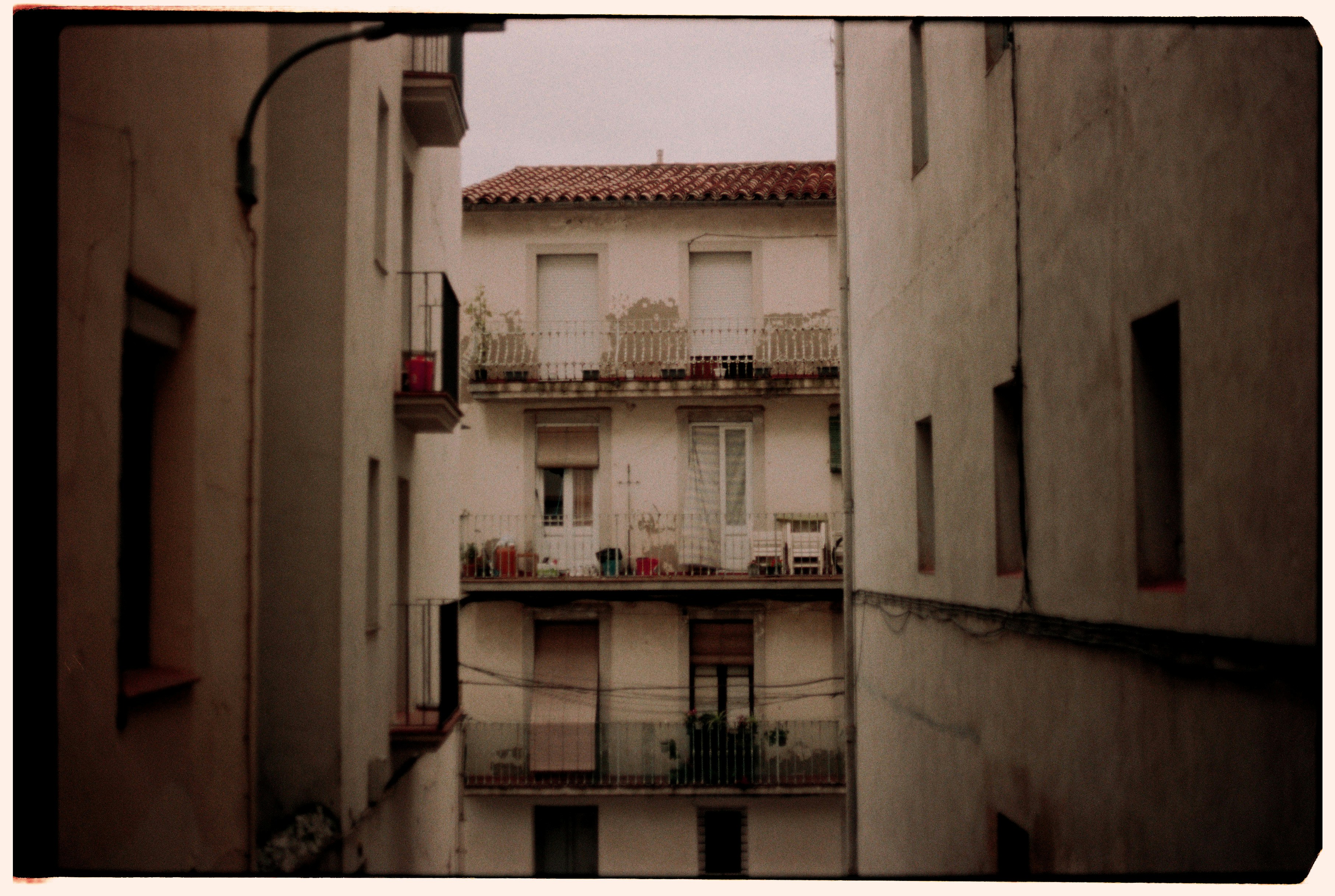 Narrow alleyway between old buildings with balconies.