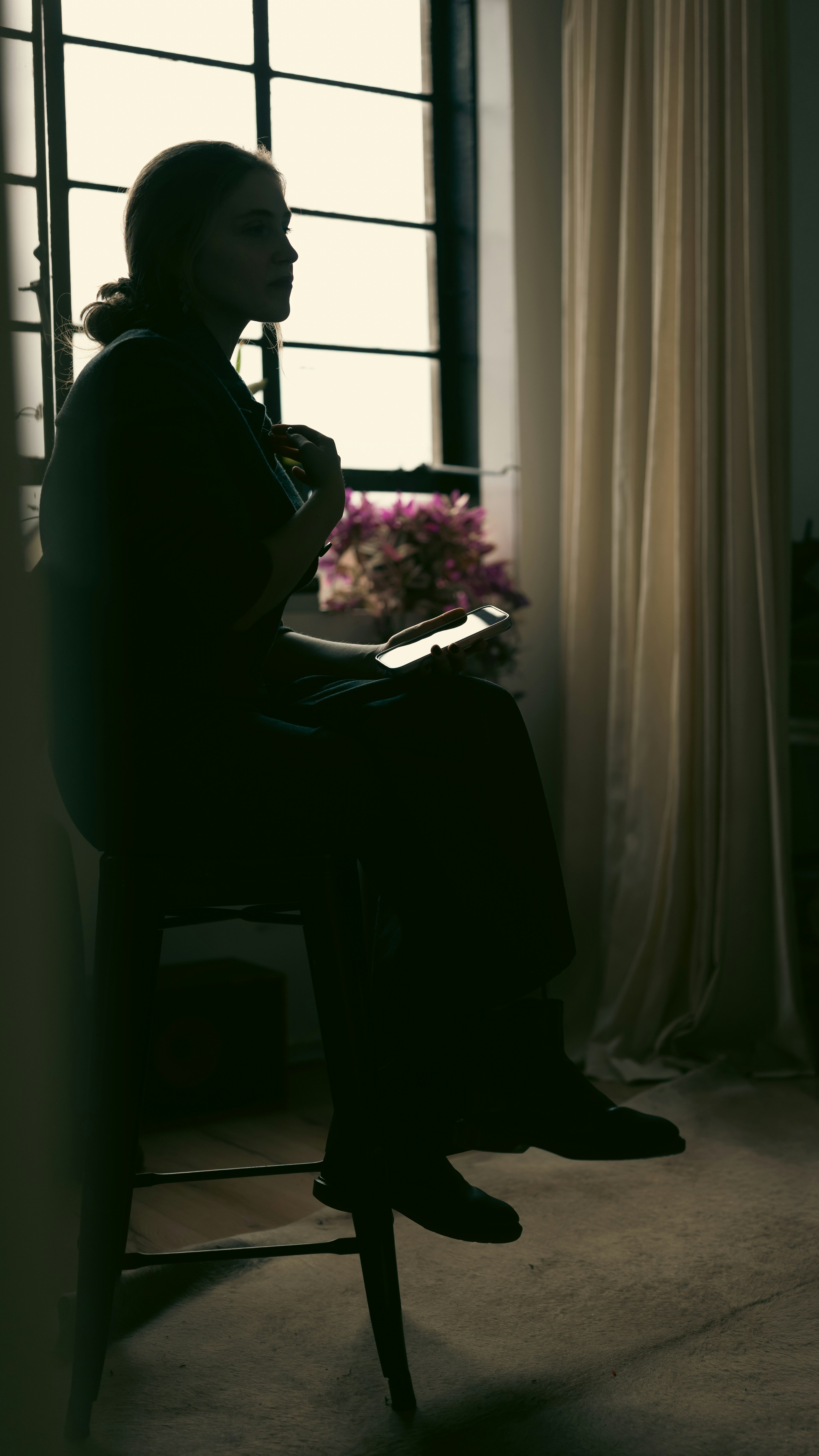 Woman sitting by window with tablet