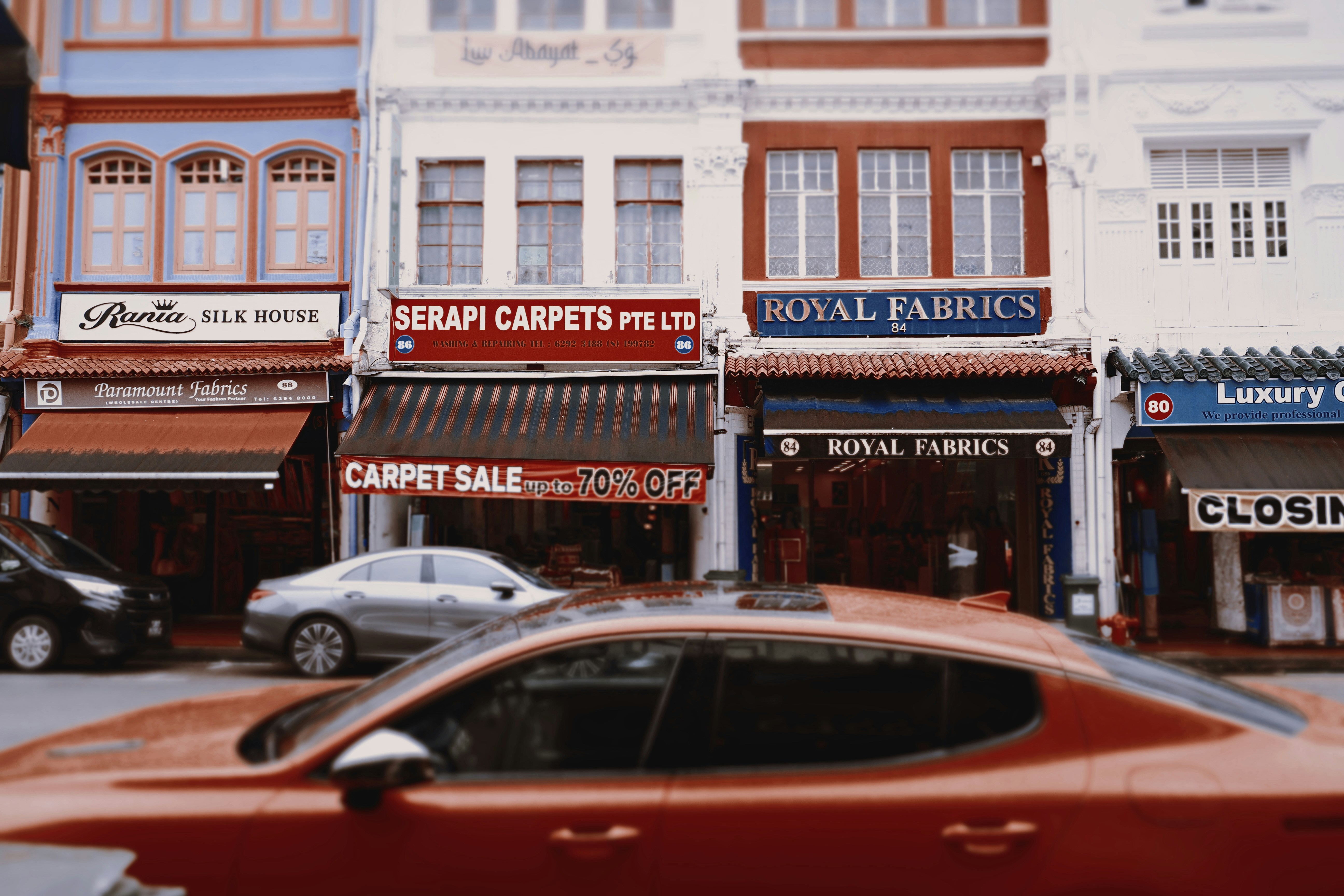 Row of shops with cars in foreground