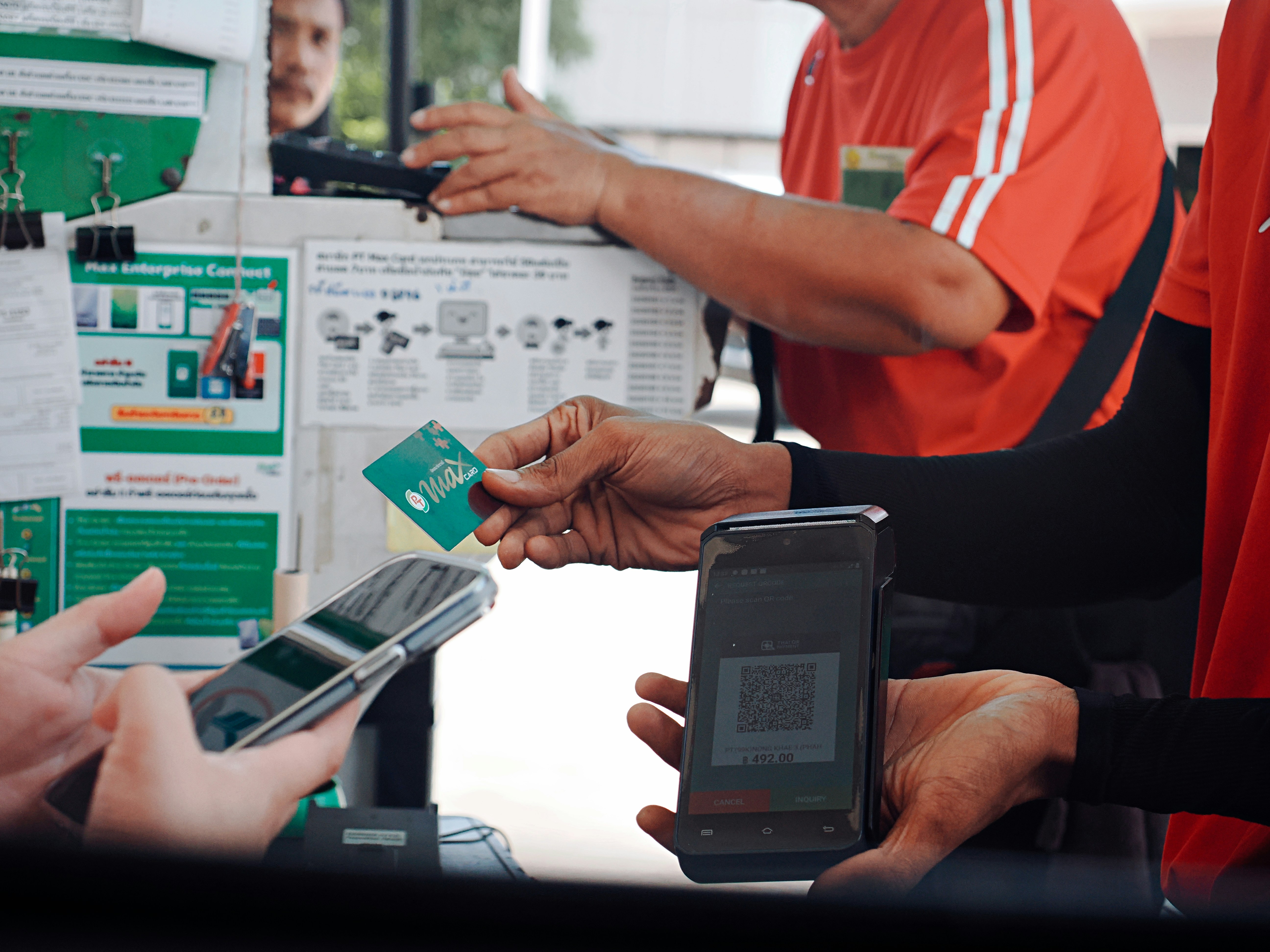 Customer paying with smartphone and credit card at checkout.