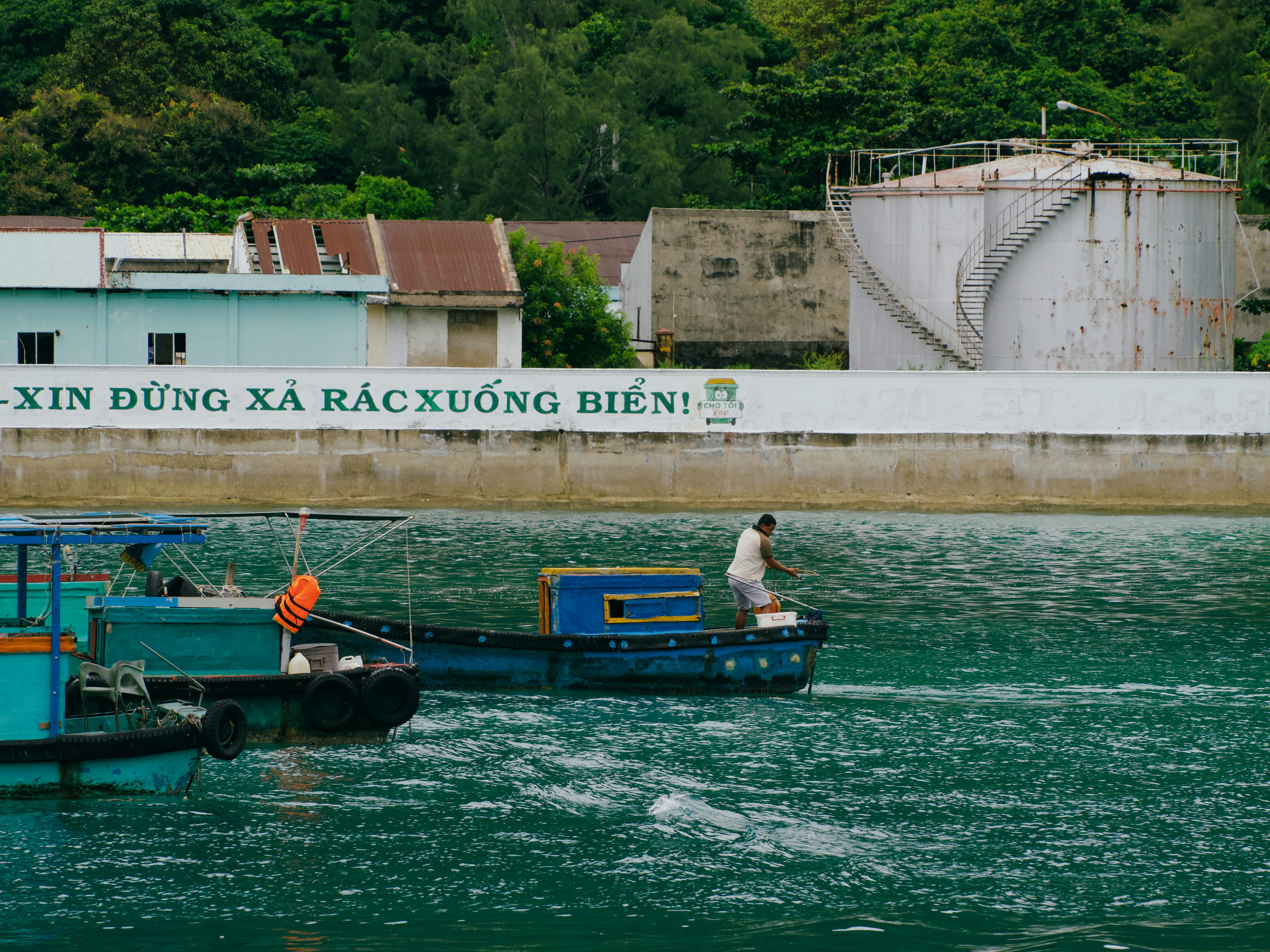 Two boats on the water near industrial buildings