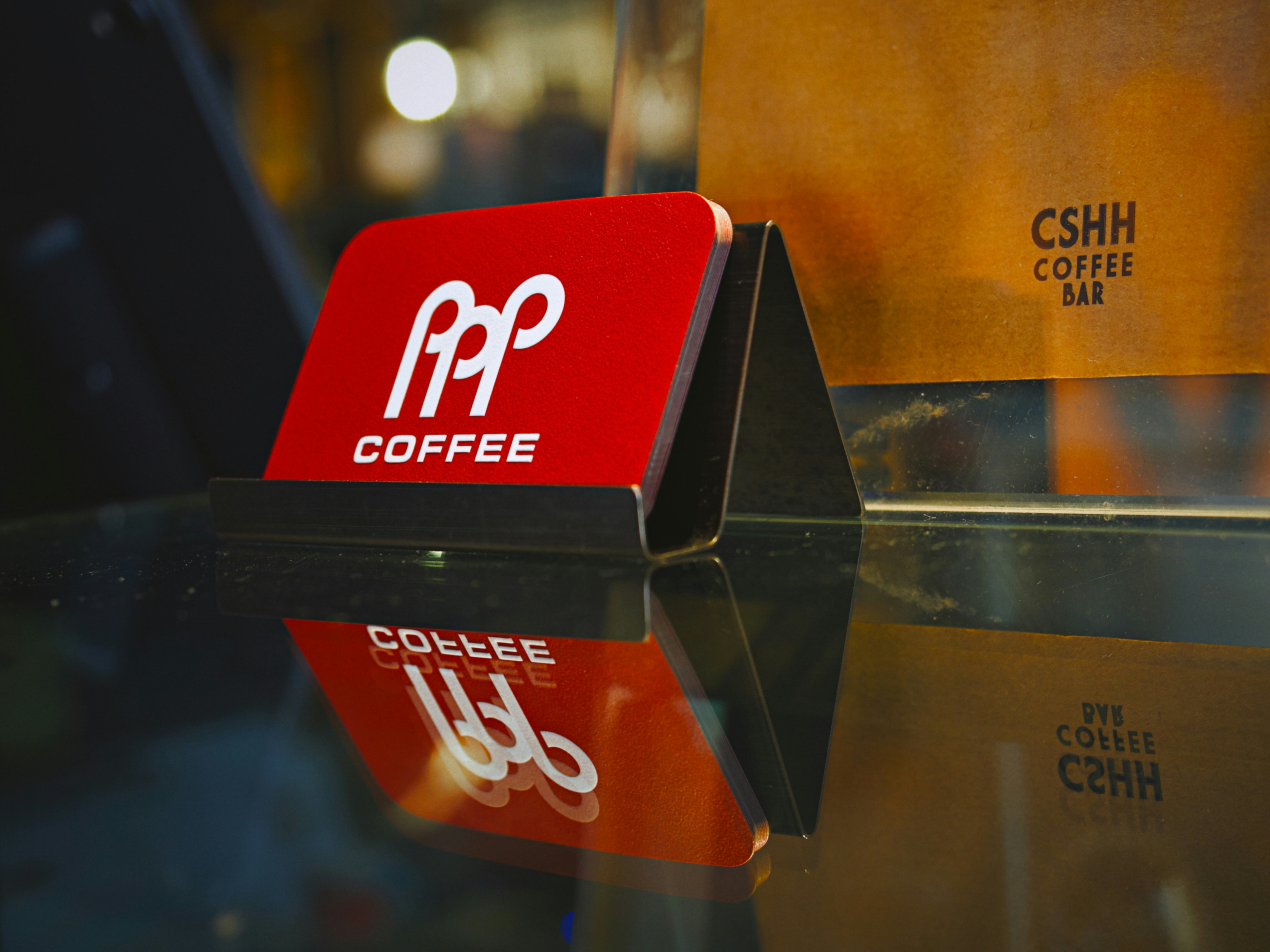 Tanda kopi merah dengan logo tercermin pada permukaan kaca