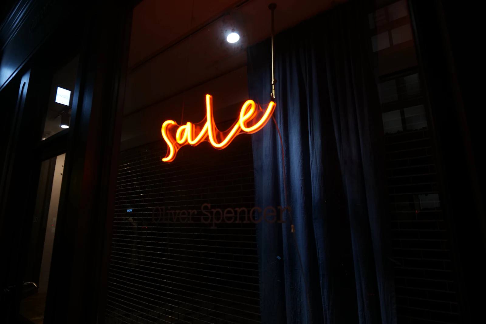 Orange neon sale sign glowing in a dark shop window – sale price rules Ireland