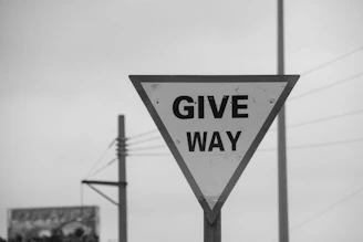 Give way traffic sign against overcast sky