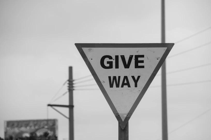 Give way traffic sign against overcast sky