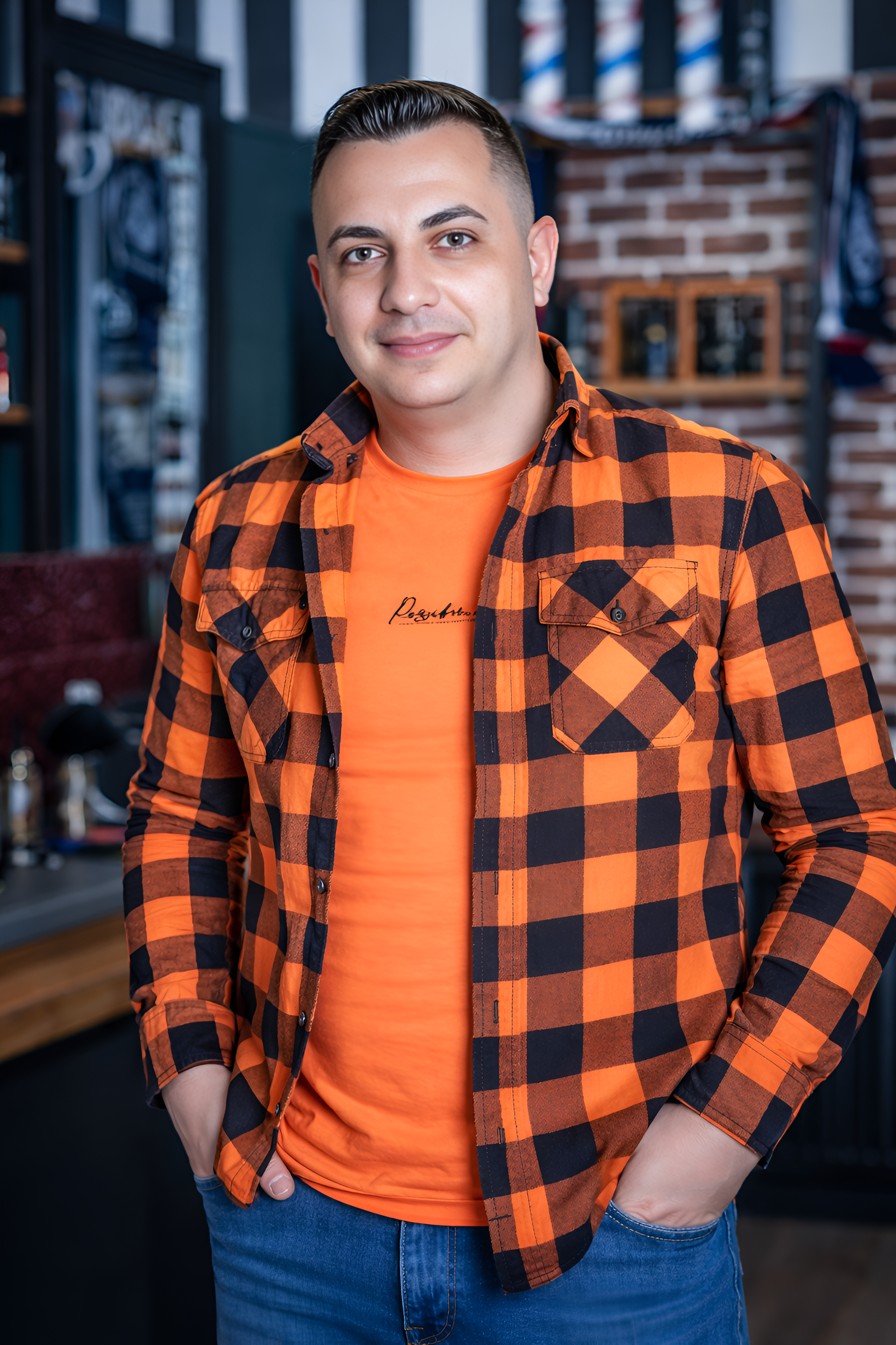 Uomo con camicia a quadri arancione e jeans nel barbiere.